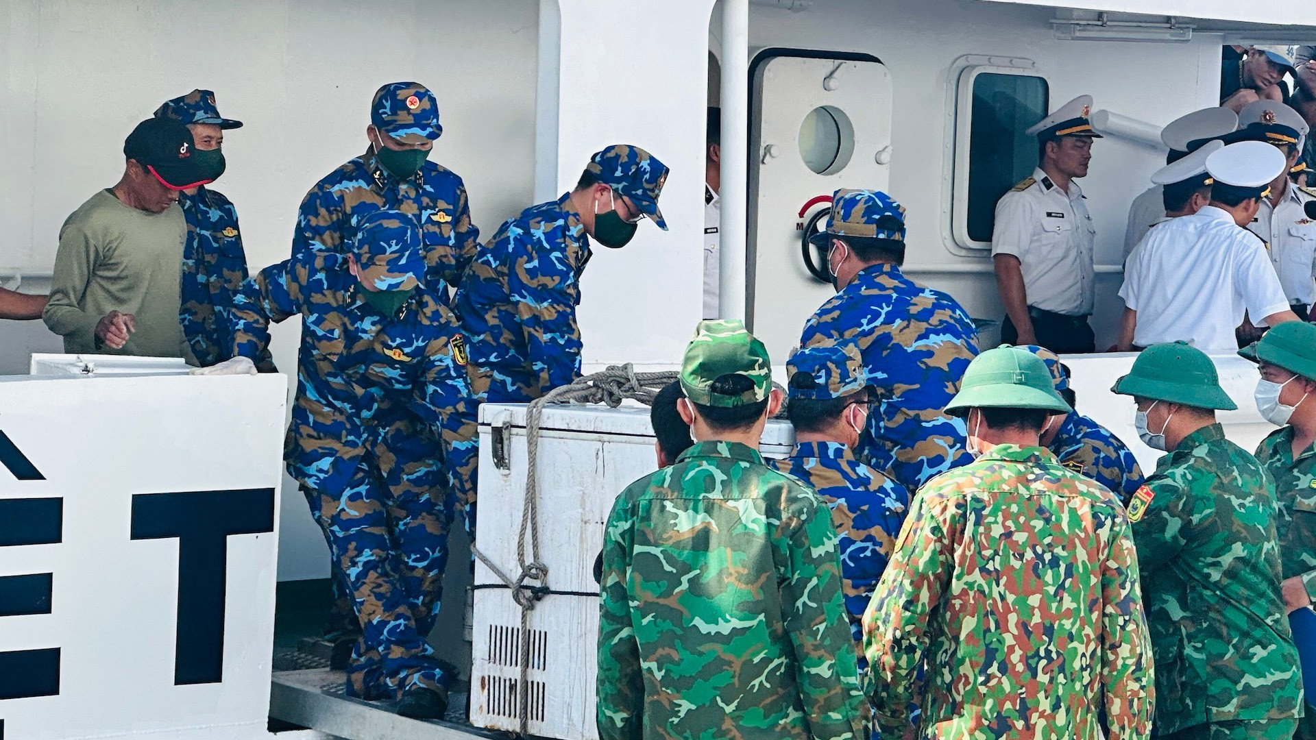 Đưa 2 thi thể ngư dân lên xe cứu thương.