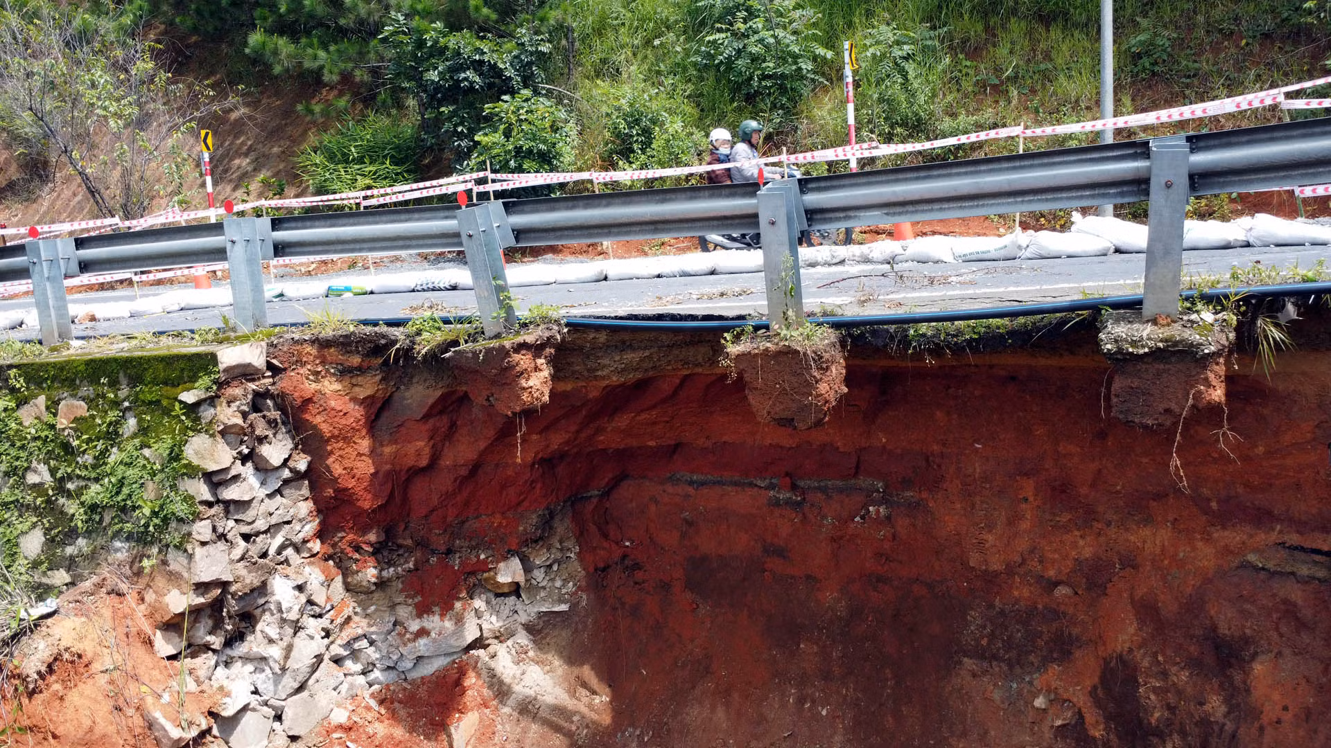 Những trụ lan can đèo bị “mất chân” sau khi lượng lớn đất đá phía dưới sạt trượt.