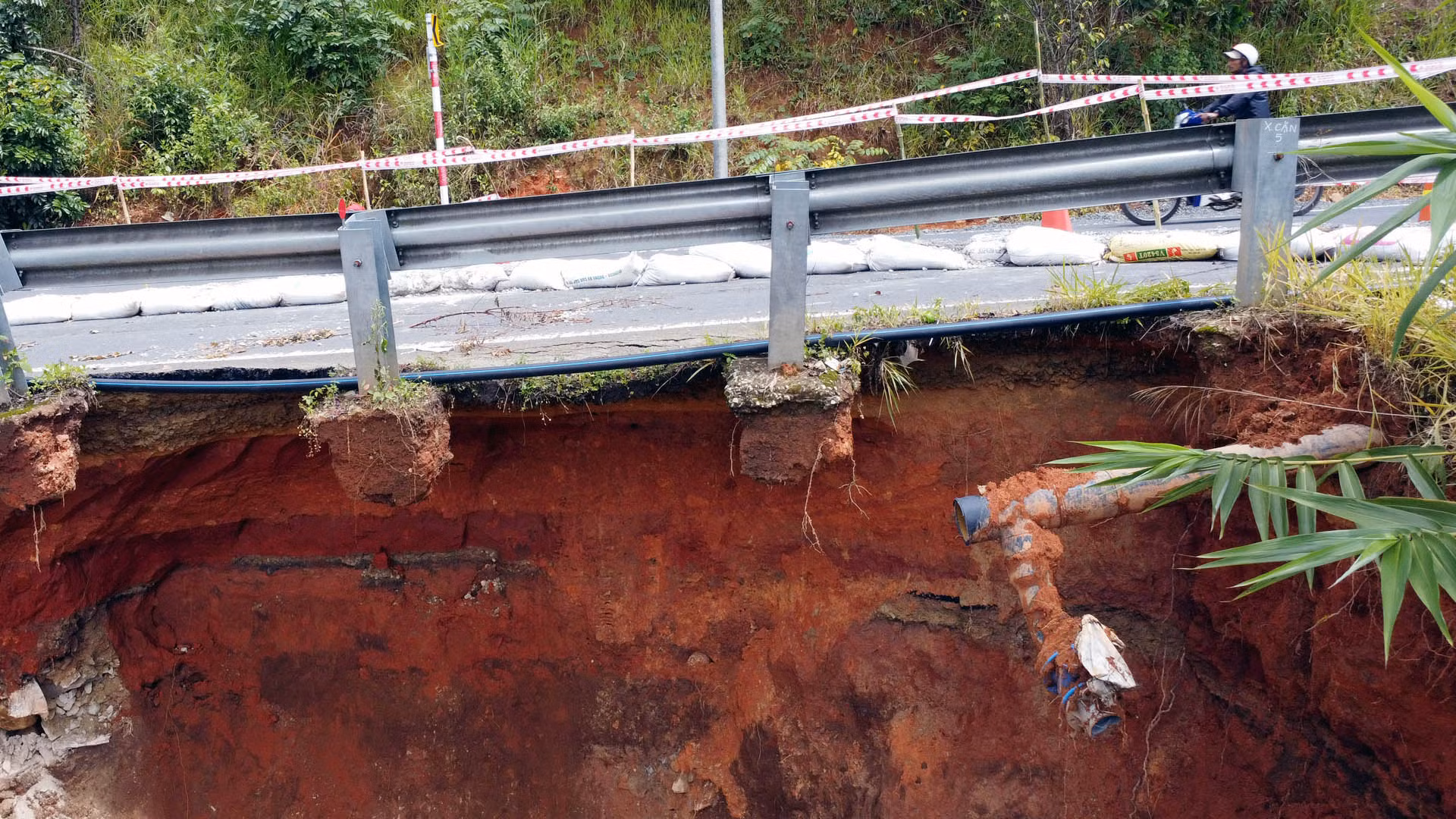 Cơ quan chức năng đã làm gờ bê-tông, đắp bao tải đất để hạn chế nước chảy vào vị trí sạt lở, di dời hệ thống cấp nước khỏi khu vực.