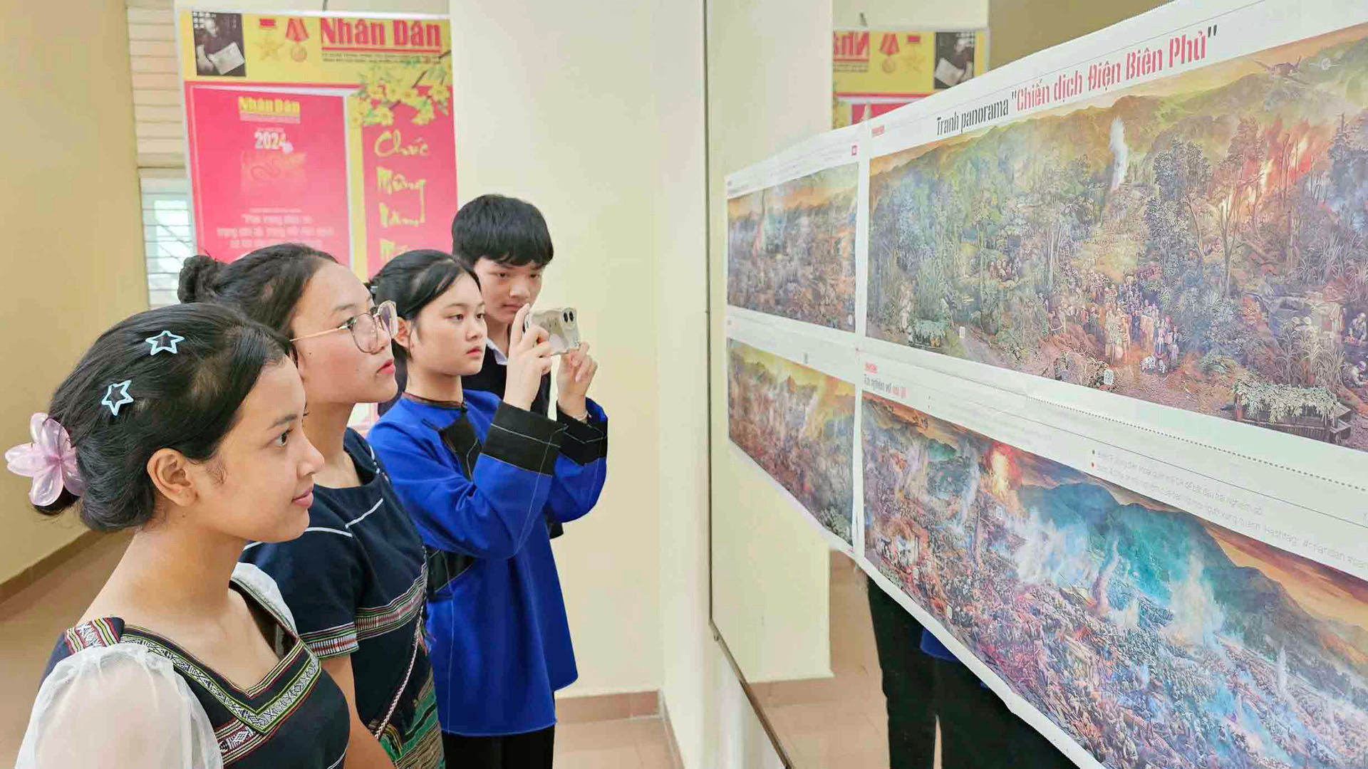 Các bạn trẻ đồng bào dân tộc thiểu số quét mã QR khám phá "bí ẩn" trên ấn bản tranh panorama "Chiến dịch Điện Biên Phủ".