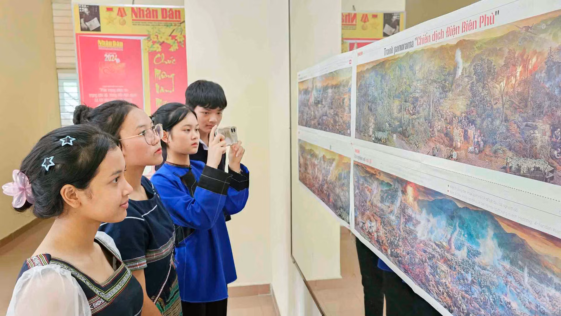 Các bạn trẻ đồng bào dân tộc thiểu số quét mã QR khám phá "bí ẩn" trên ấn bản tranh panorama "Chiến dịch Điện Biên Phủ".
