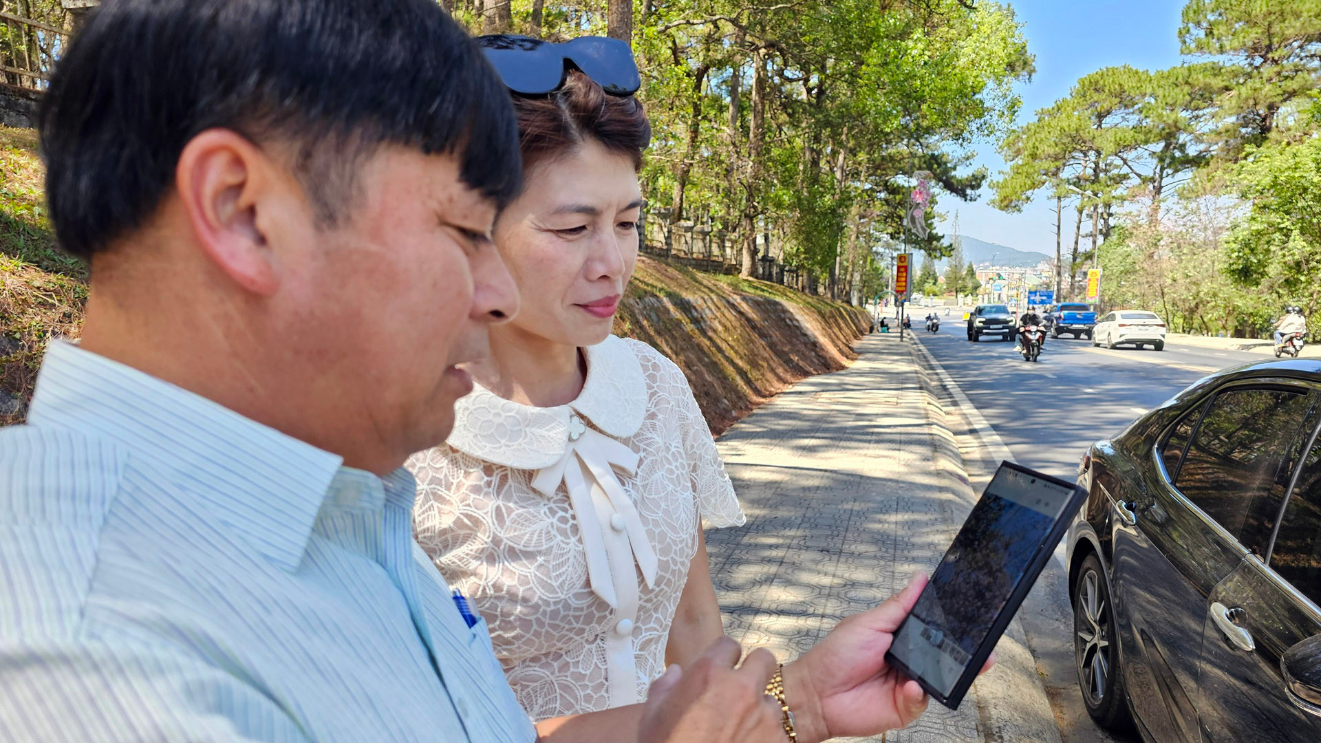 Ông Lê Hữu Phước và chị Nguyễn Nghĩa xem lại những tấm ảnh mai anh đào vừa chụp.