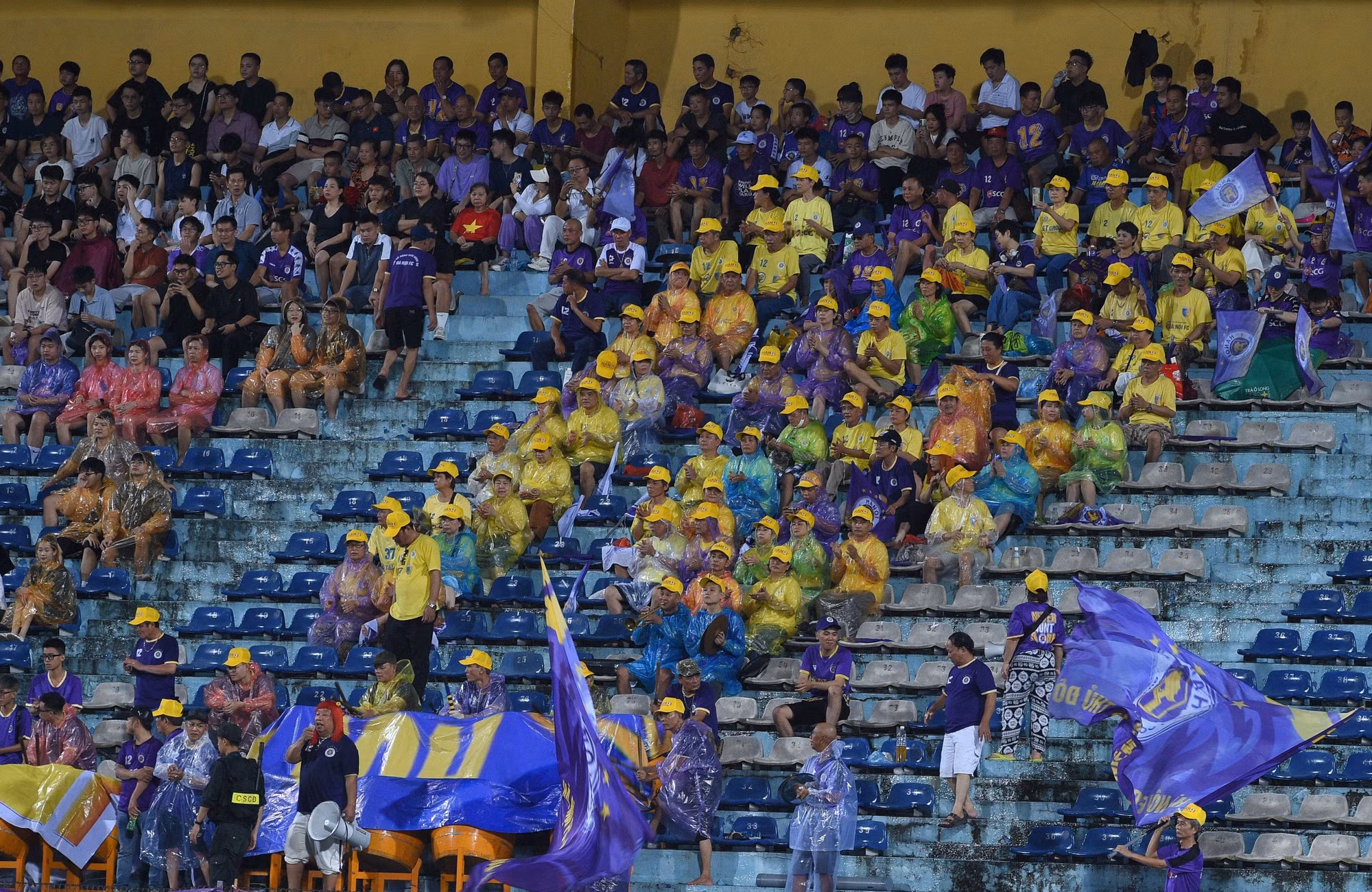 Hàng ngàn cổ động viên đội mưa tới sân Hàng Đẫy cổ vũ cho hai đội.