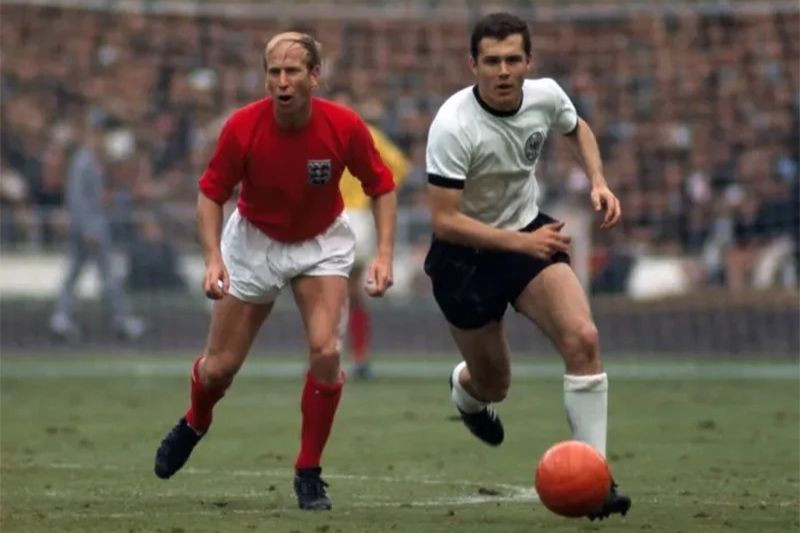 Franz Beckenbauer xuất hiện ở World Cup lần đầu tiên vào năm 1966. Ở trận chung kết gặp tuyển Anh ông đối đầu và được giao nhiệm vụ kèm cặp Bobby Charlton. Trận này Tây Đức thất bại 2-4 sau 120 phút. (Ảnh: Rolls Press/Popperfoto/Getty Images) Franz Beckenbauer xuất hiện ở World Cup lần đầu tiên vào năm 1966. Ở trận chung kết gặp tuyển Anh ông đối đầu và được giao nhiệm vụ kèm cặp Bobby Charlton. Trận này Tây Đức thất bại 2-4 sau 120 phút. (Ảnh: Rolls Press/Popperfoto/Getty Images)