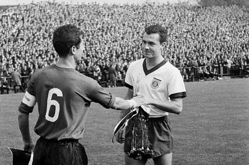 Franz Beckenbauer bắt đầu sự nghiệp bóng đá tại Bayern Munich vào năm 1964 ở Regionalliga Süd trước khi được thăng hạng lên hạng cao nhất. Hình ảnh ông đang trao đổi cờ hiệu với đội trưởng Heinz Lowin của Borussia Mönchenladbach trước trận tại Bundesliga 1965/1966. (Ảnh: Werner Otto/Ullstein Bild/Getty Images) Franz Beckenbauer bắt đầu sự nghiệp bóng đá tại Bayern Munich vào năm 1964 ở Regionalliga Süd trước khi được thăng hạng lên hạng cao nhất. Hình ảnh ông đang trao đổi cờ hiệu với đội trưởng Heinz Lowin của Borussia Mönchenladbach trước trận tại Bundesliga 1965/1966. (Ảnh: Werner Otto/Ullstein Bild/Getty Images)