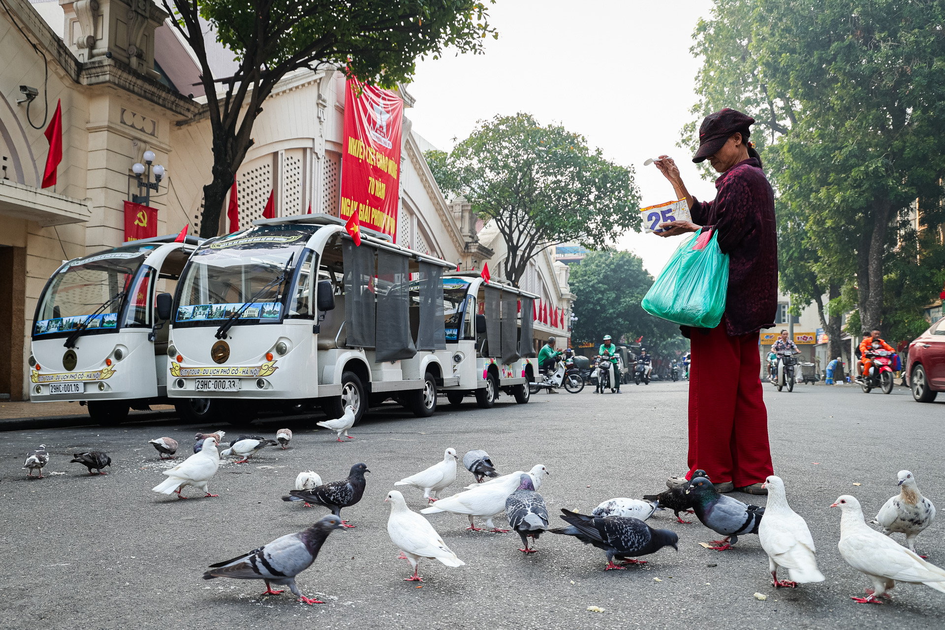 Người dân thong thả cho chim bồ câu ăn, một hình ảnh thân thuộc đậm chất Hà Nội.