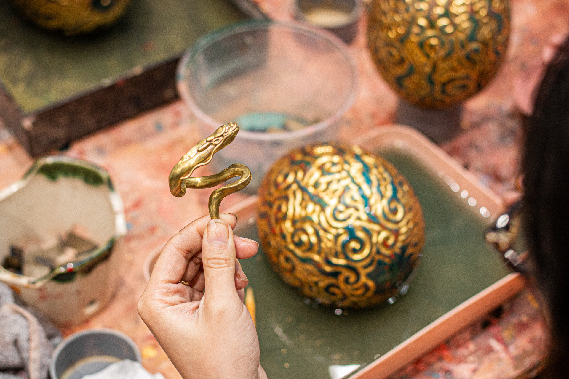 Chú rồng nhỏ được làm bằng 2 chất liệu: đồng thau và bạc nguyên khối thủ công hoàn toàn. Khi để phía trên, rồng như đang bay lên từ quả trứng trong dáng “Thăng Long” hoặc đặt dưới đế ngắm quả trứng khổng lồ trong thế nằm nghiêng tuỳ biến ở bất kì góc nào.