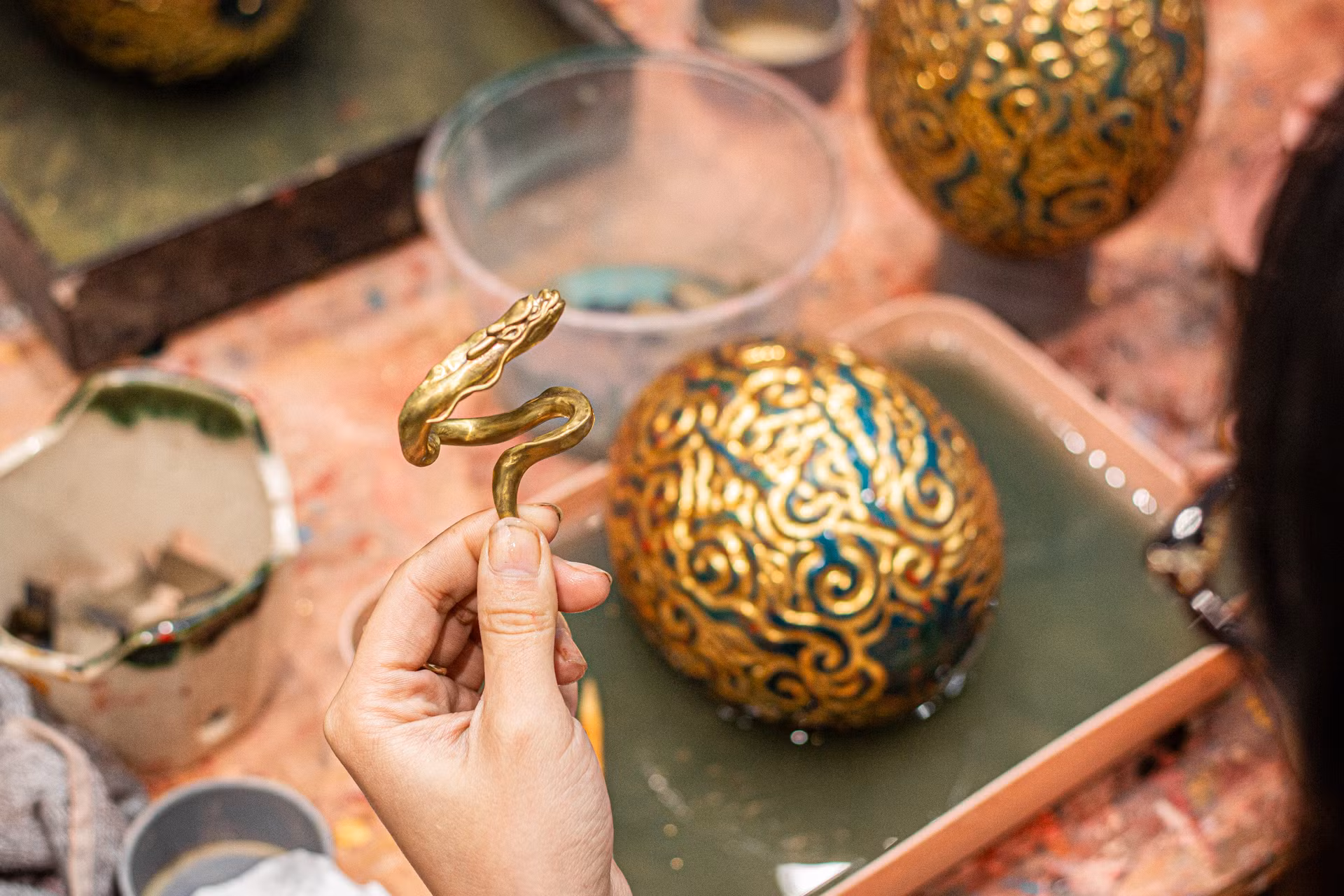 Chú rồng nhỏ được làm bằng 2 chất liệu: đồng thau và bạc nguyên khối thủ công hoàn toàn. Khi để phía trên, rồng như đang bay lên từ quả trứng trong dáng “Thăng Long” hoặc đặt dưới đế ngắm quả trứng khổng lồ trong thế nằm nghiêng tuỳ biến ở bất kì góc nào.