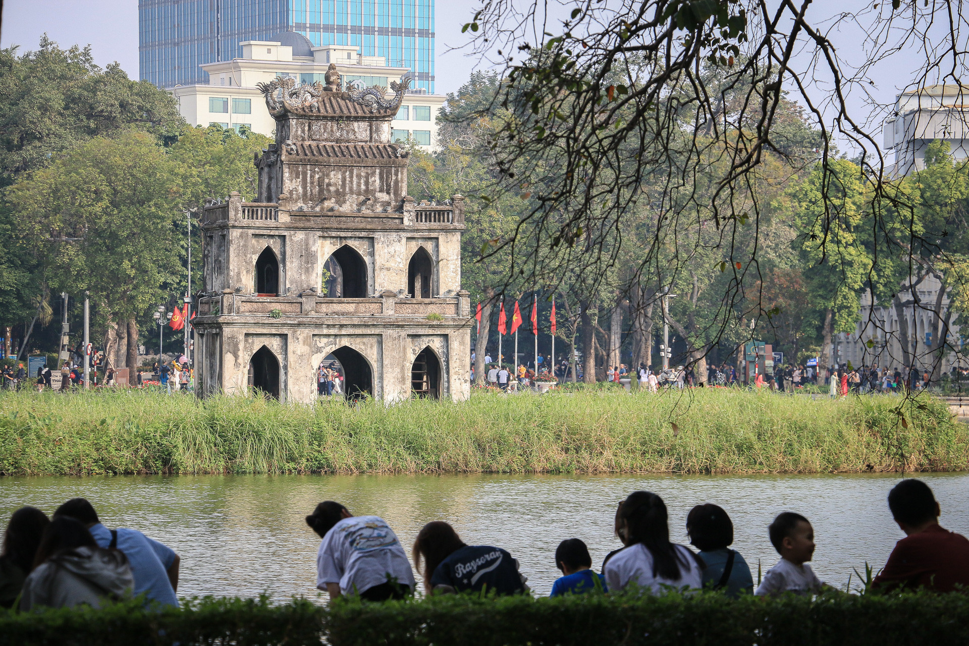 Nhiều người dân chọn khu vực có bóng mát, ngồi nghỉ ngơi bên khu vực Bờ Hồ.