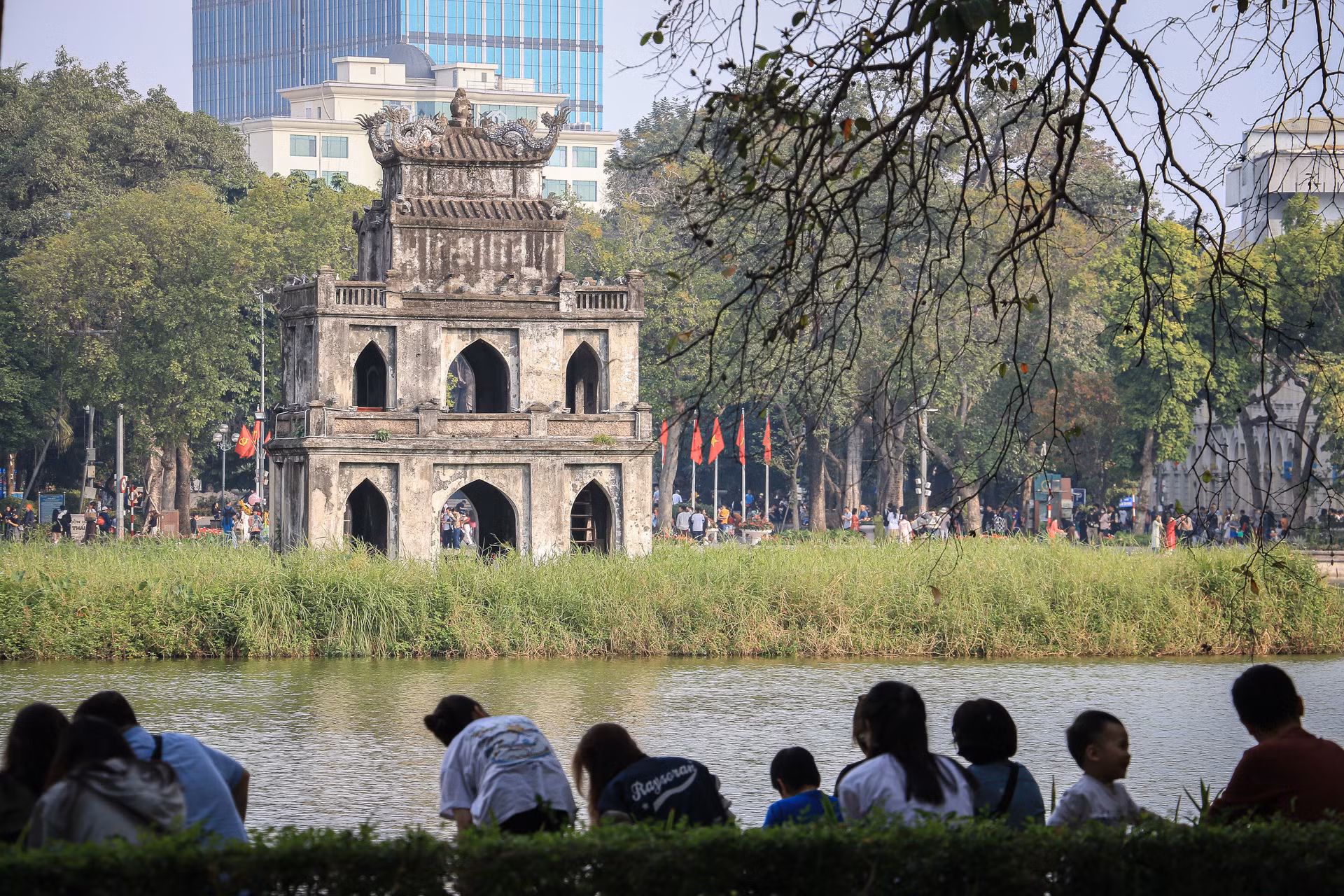 Nhiều người dân chọn khu vực có bóng mát, ngồi nghỉ ngơi bên khu vực Bờ Hồ.