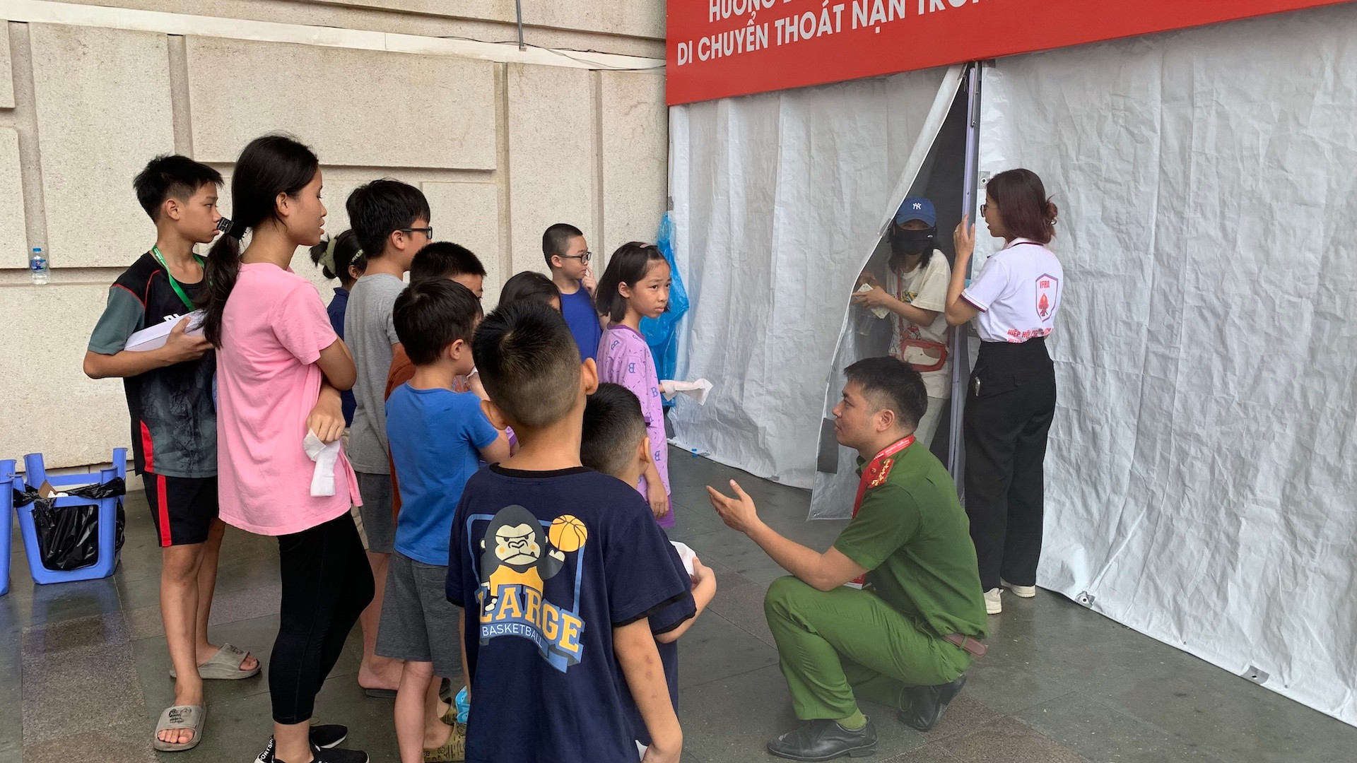 Các em nhỏ chăm chú lắng nghe hướng dẫn thực hành kỹ năng cứu người, di chuyển thoát nạn trong môi trường nhiều khói.