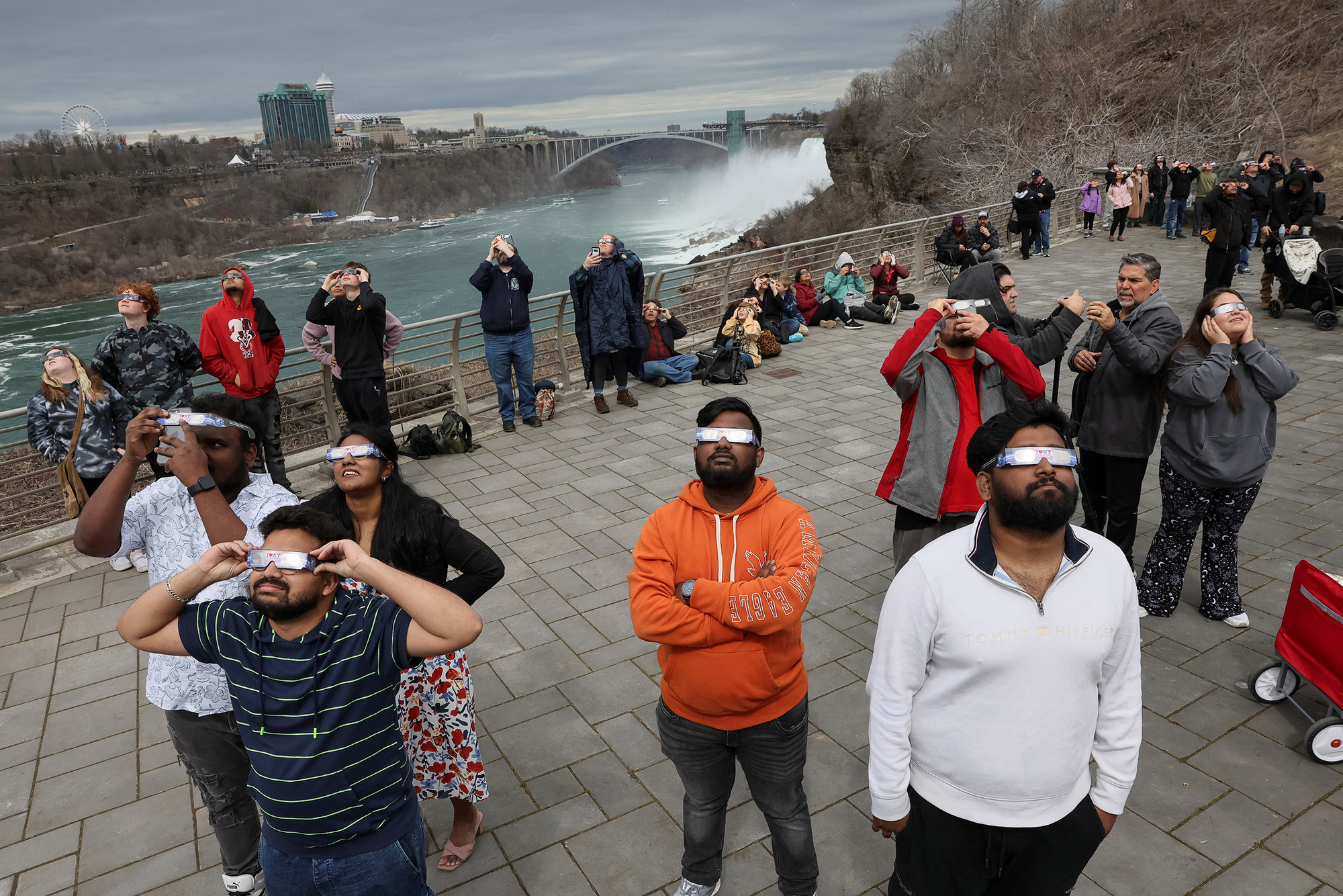 Đông đảo người dân tập trung tại thác Niagara, Mỹ để ngắm nhìn bầu trời khi mặt trăng che khuất một phần mặt trời. (Ảnh: Reuters)