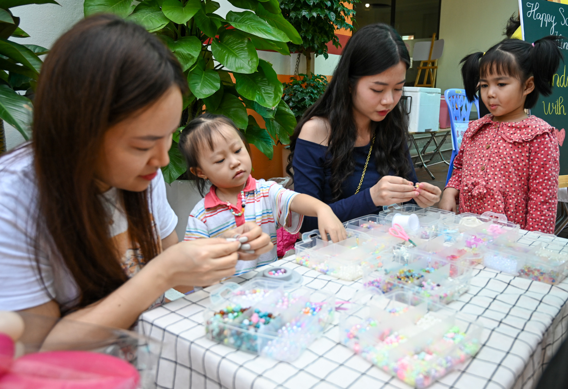 Các em nhỏ thích thú theo dõi các công đoạn làm các sản phẩm trang sức handmade.