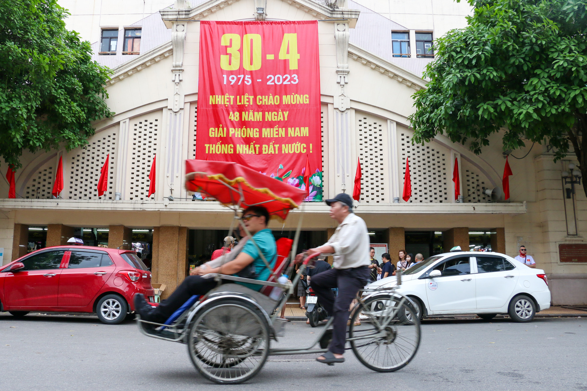 Tấm áp phích khổ lớn kỷ niệm ngày thống nhất đất nước được treo trang trọng ở chợ Đồng Xuân.