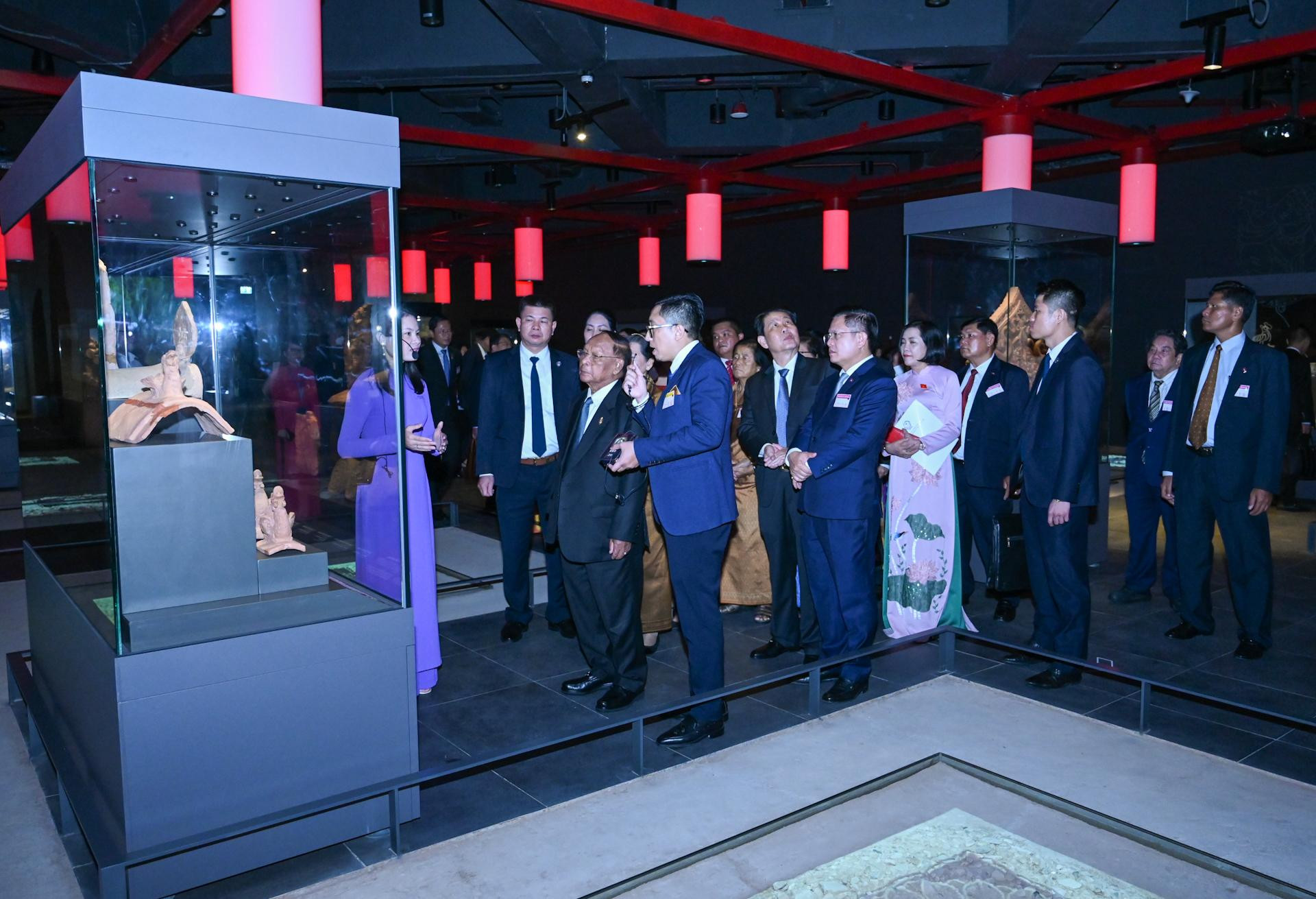 Chủ tịch Quốc hội Campuchia và các đại biểu nghe giới thiệu về các hiện vật tại khu trưng bày.
