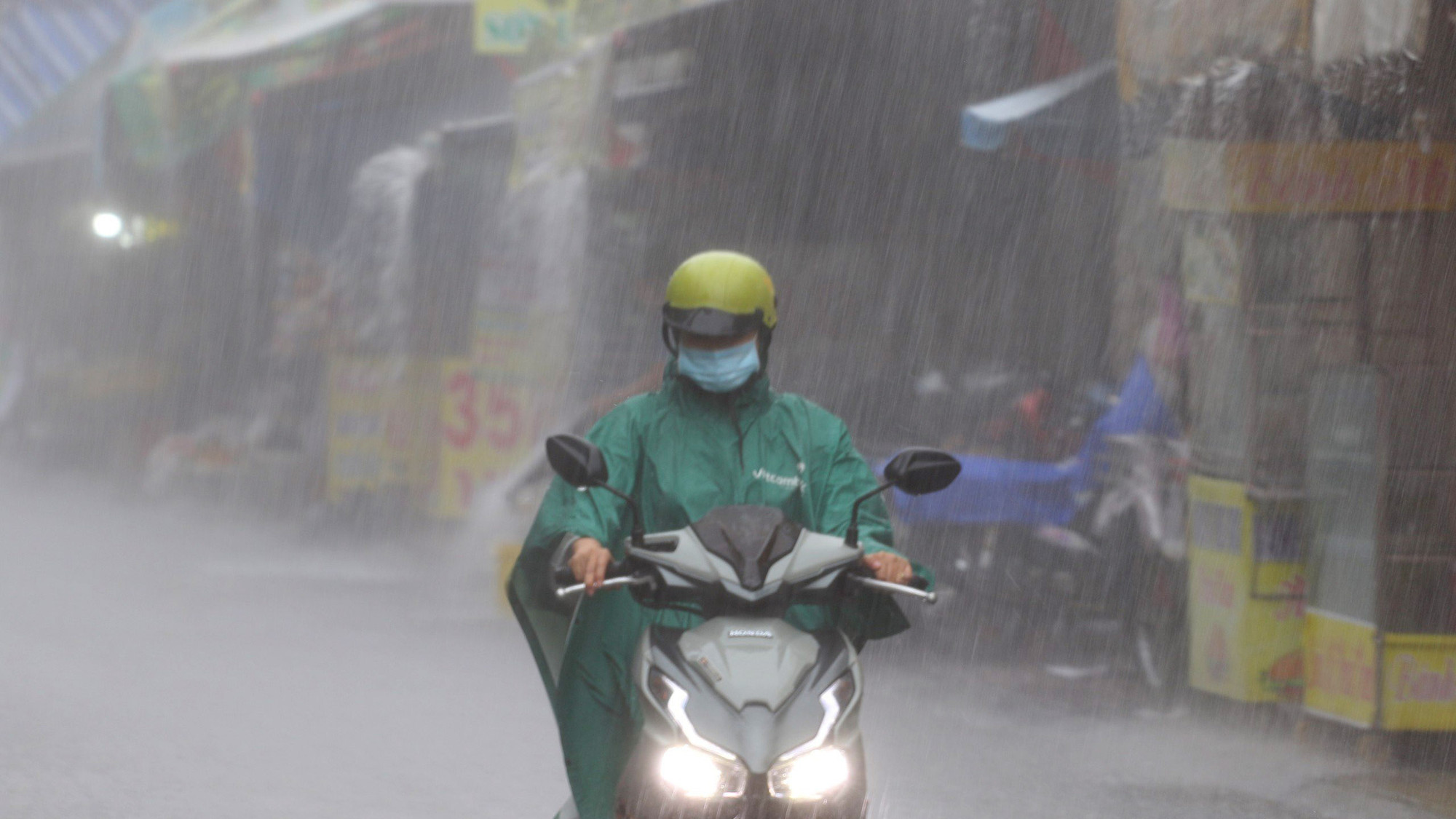 Mưa kèm theo gió giật mạnh làm áo mưa có lúc bay che kín mặt của nhiều người khi đang di chuyển trên đường Trần Văn Quang, quận Tân Bình.