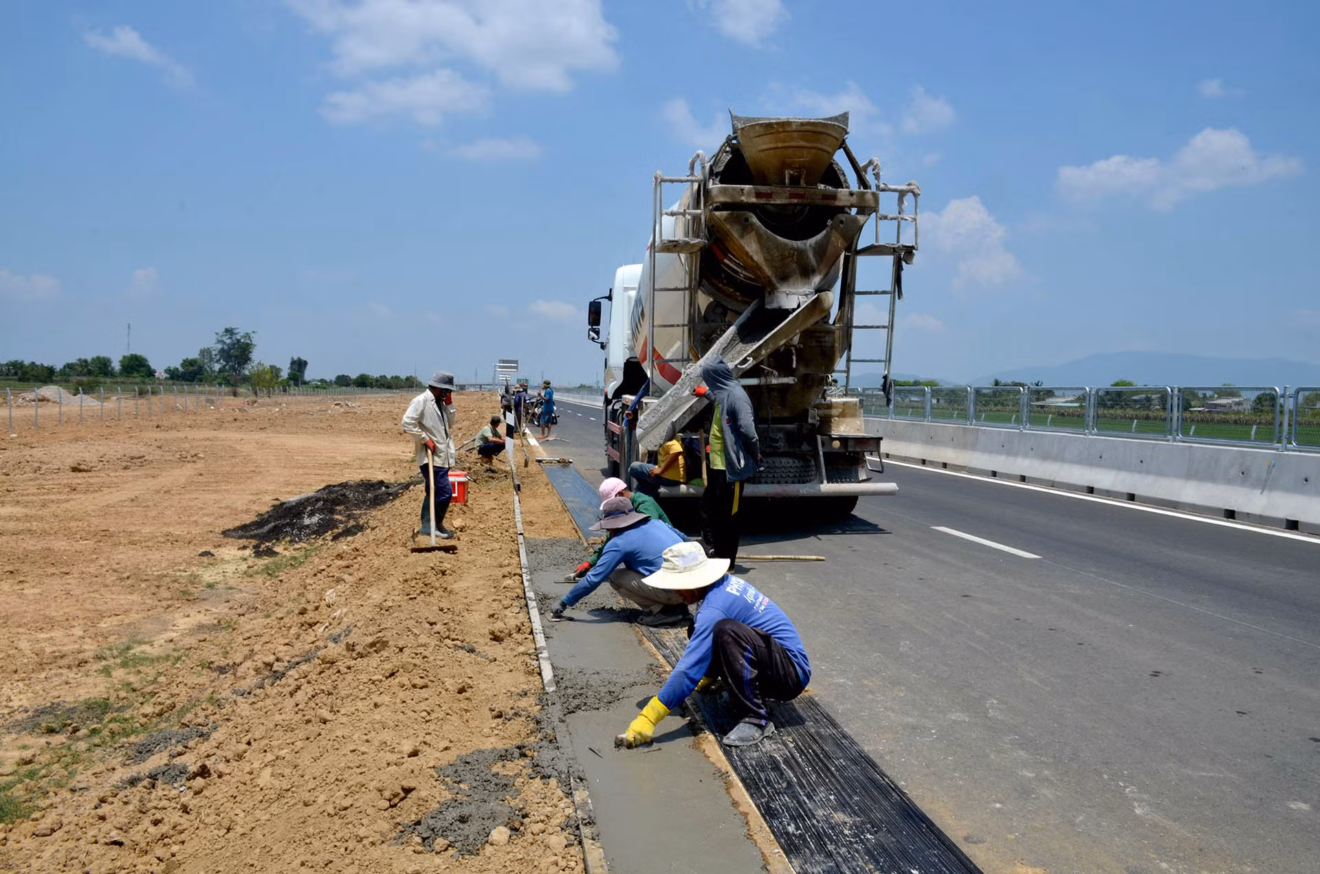 Thi công đổ bê-tông vệ đường để gắn hộ lan tôn sóng trên cao tốc.