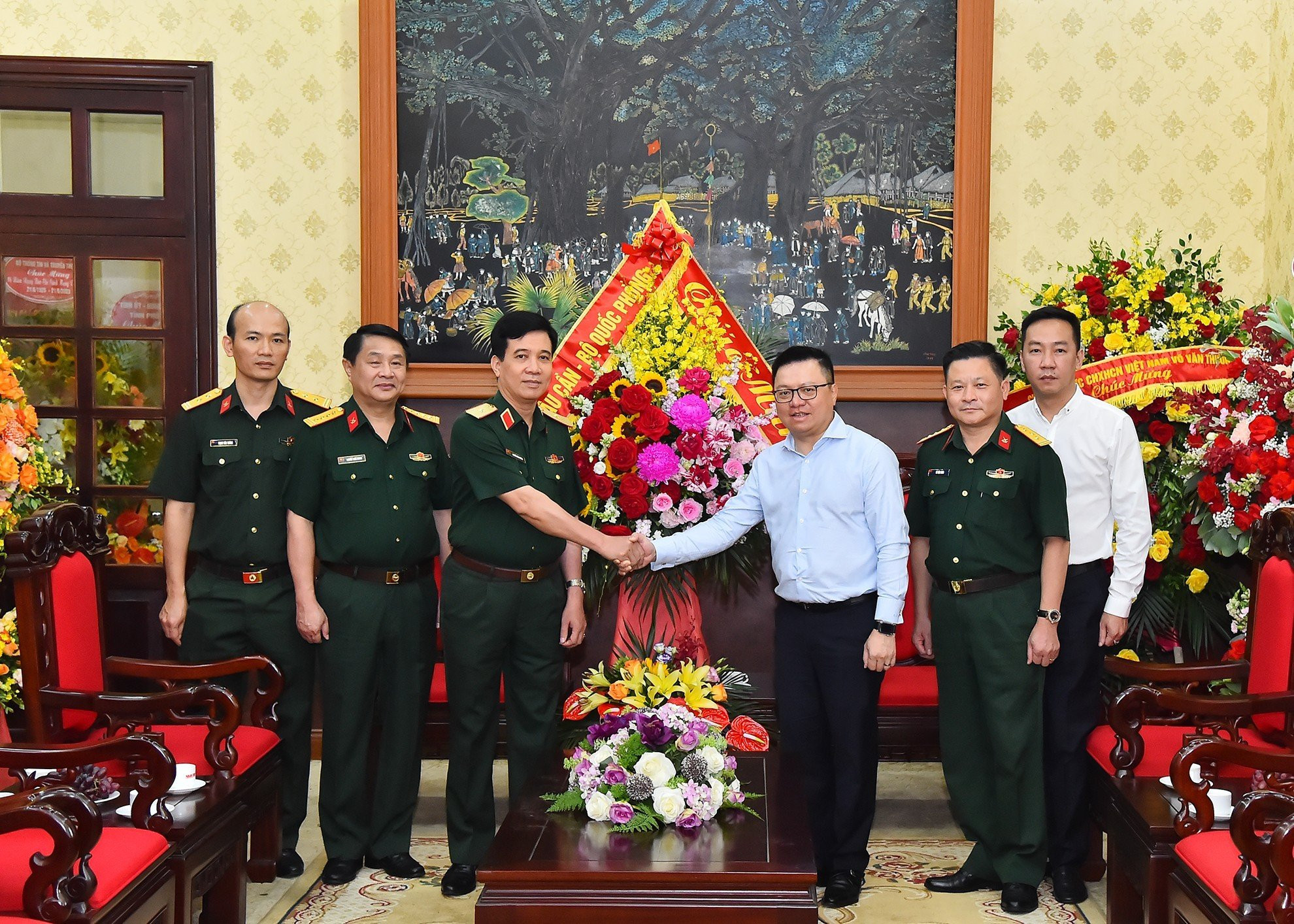 Thiếu tướng Nguyễn Văn Cường, Phó Chính ủy Tổng cục Hậu cần tặng hoa chúc mừng Báo Nhân Dân.