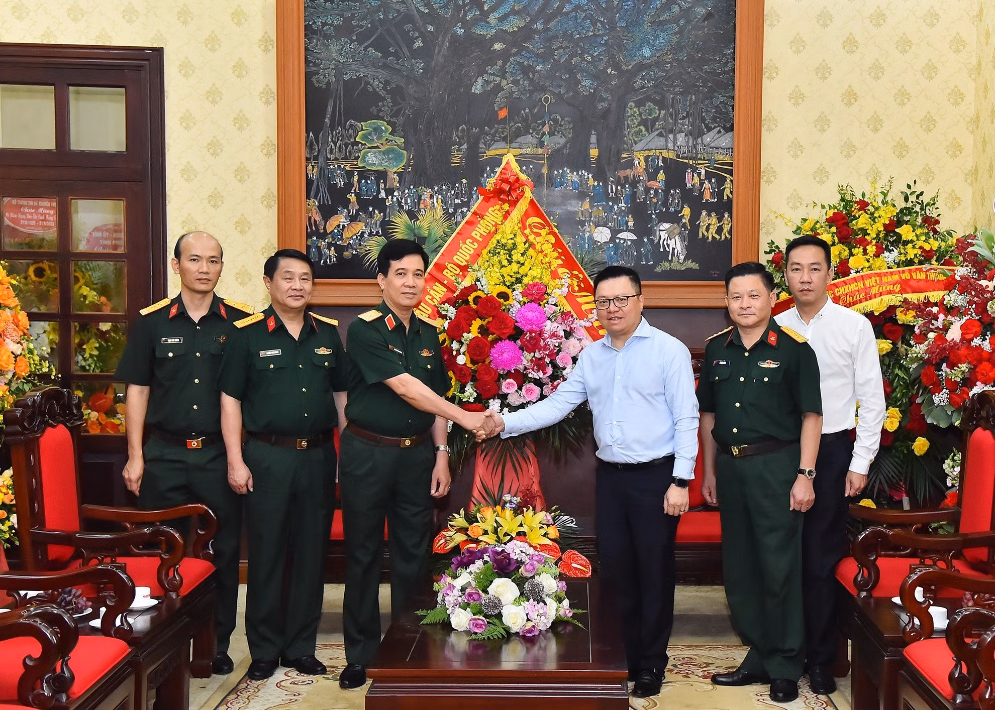 Thiếu tướng Nguyễn Văn Cường, Phó Chính ủy Tổng cục Hậu cần tặng hoa chúc mừng Báo Nhân Dân.