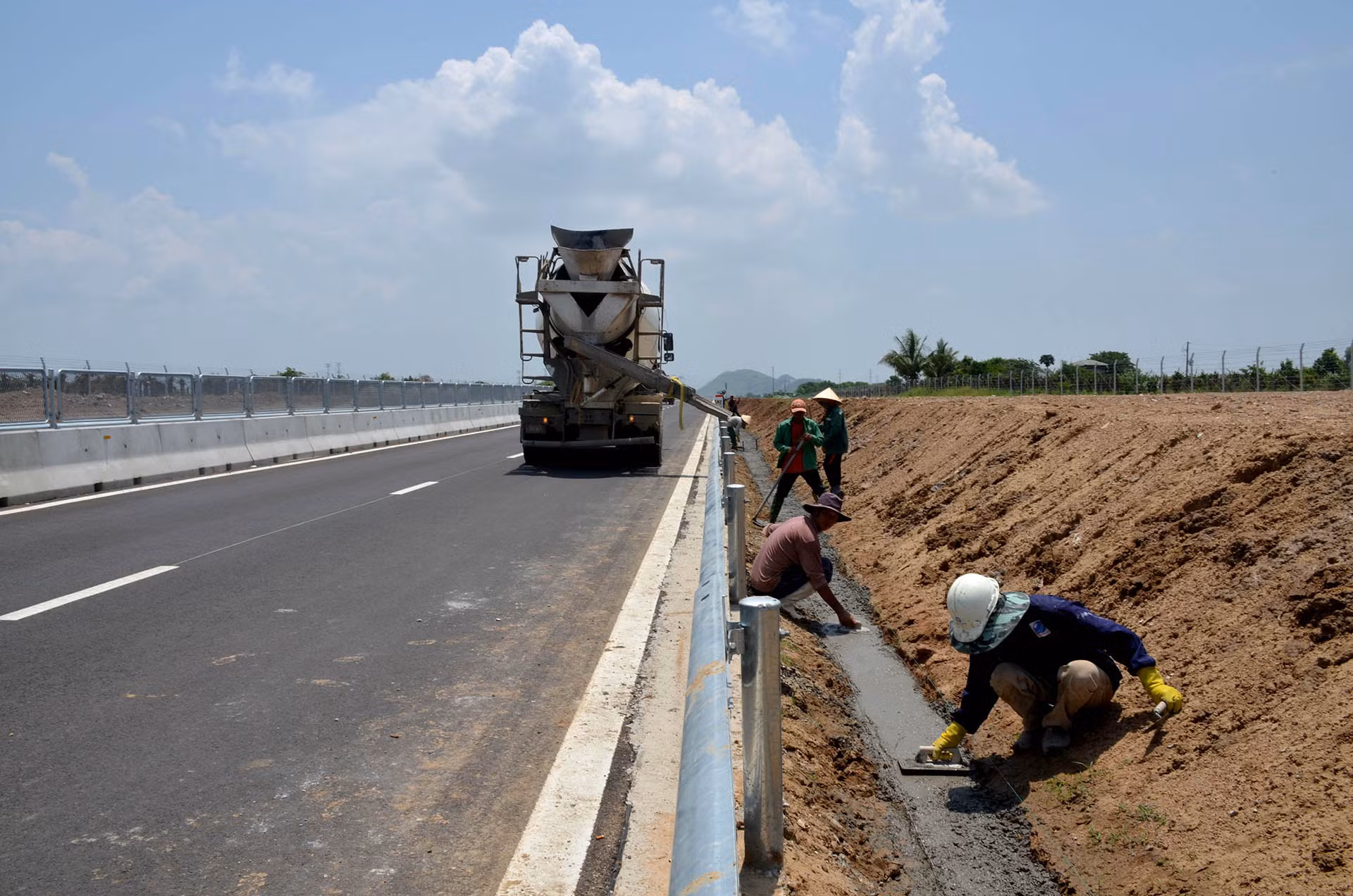 Các công nhân đang thi công rãnh thoát nước dọc, thuộc gói thầu XL-04 cao tốc Vĩnh Hảo-Phan Thiết tại vị trí thuộc địa bàn xã Thuận Hòa, huyện Hàm Thuận Bắc.