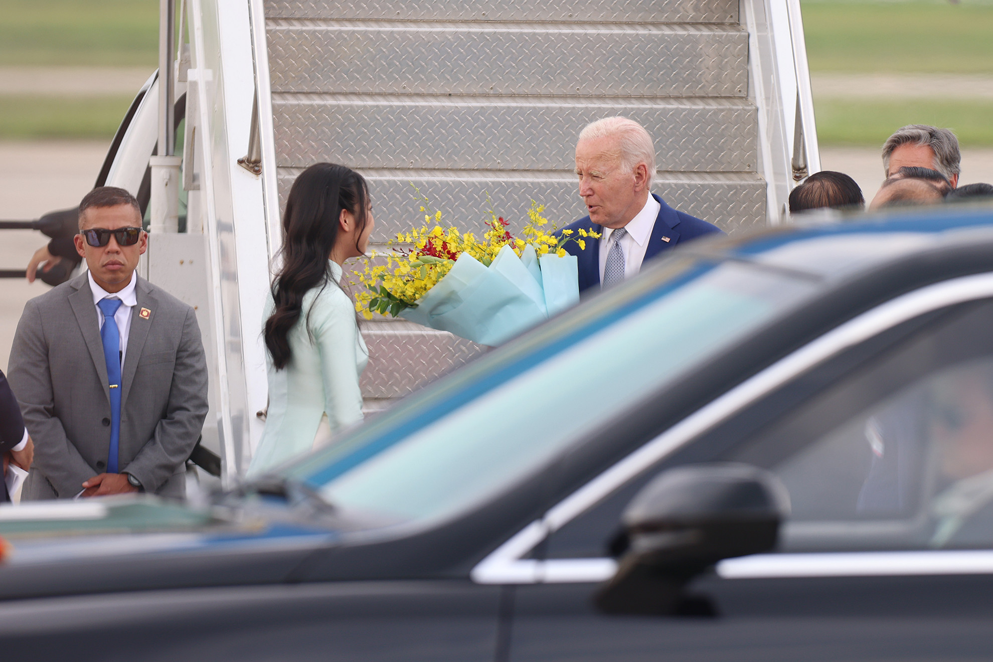 Ra đón Tổng thống Joe Biden và Đoàn đại biểu cấp cao Hoa Kỳ tại Sân bay quốc tế Nội Bài, có Ủy viên Trung ương Đảng, Trưởng ban Đối ngoại Trung ương Lê Hoài Trung; Thứ trưởng Ngoại giao Hà Kim Ngọc; Chủ tịch Hội đồng nhân dân thành phố Hà Nội Nguyễn Ngọc Tuấn; Đại sứ Việt Nam tại Hoa Kỳ Nguyễn Quốc Dũng; Cục trưởng Cục Lễ tân Nhà nước, Bộ Ngoại giao, Nguyễn Việt Dũng. Trong ảnh: Thiếu nữ Thủ đô tặng hoa, chào mừng Tổng thống Hoa Kỳ Joe Biden đến Hà Nội, bắt đầu chuyến thăm cấp Nhà nước tới Việt Nam.