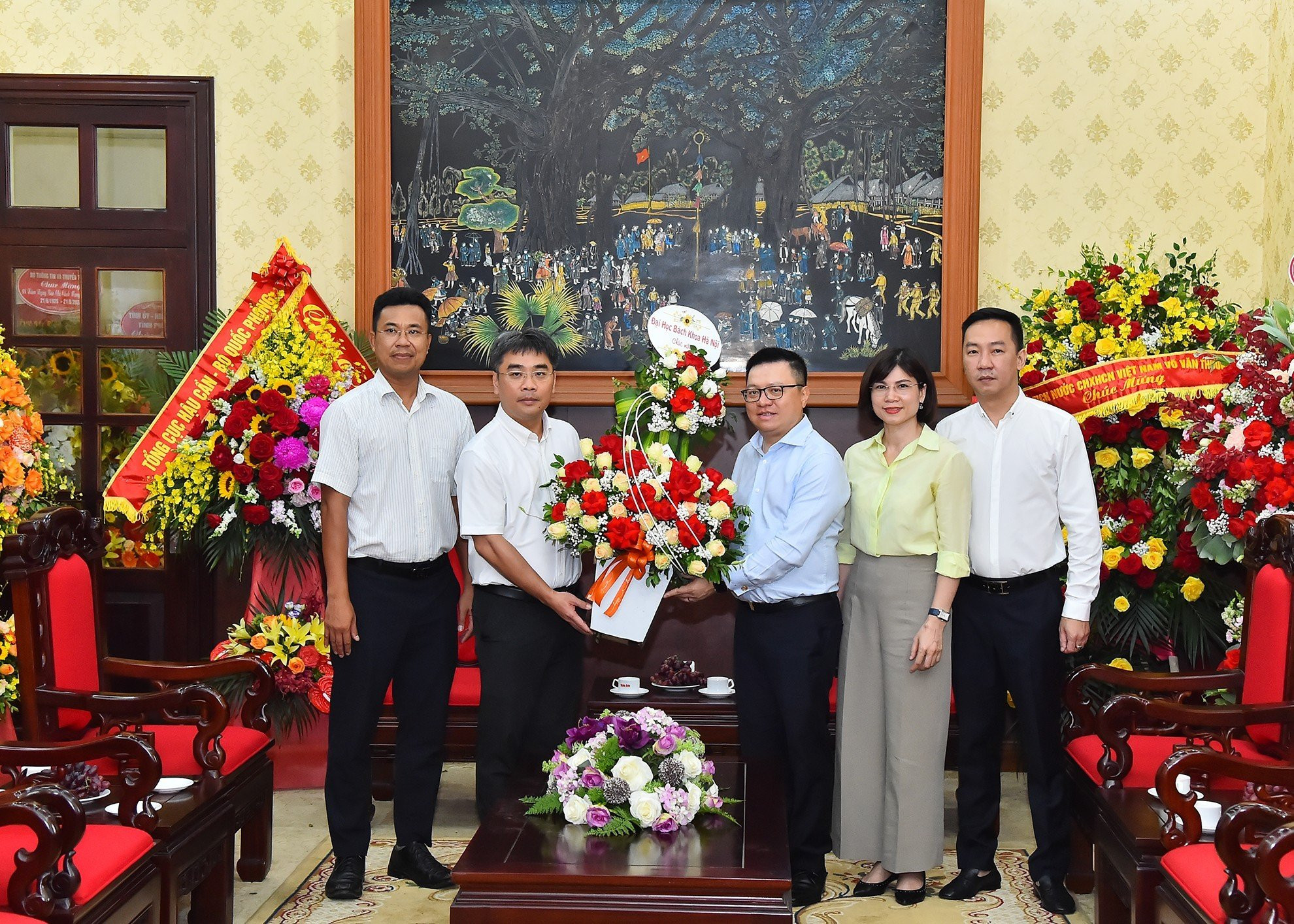 Phó Giáo sư Huỳnh Đăng Chính, Phó Giám đốc Đại học Bách khoa Hà Nội tặng hoa, chúc mừng Báo Nhân Dân.