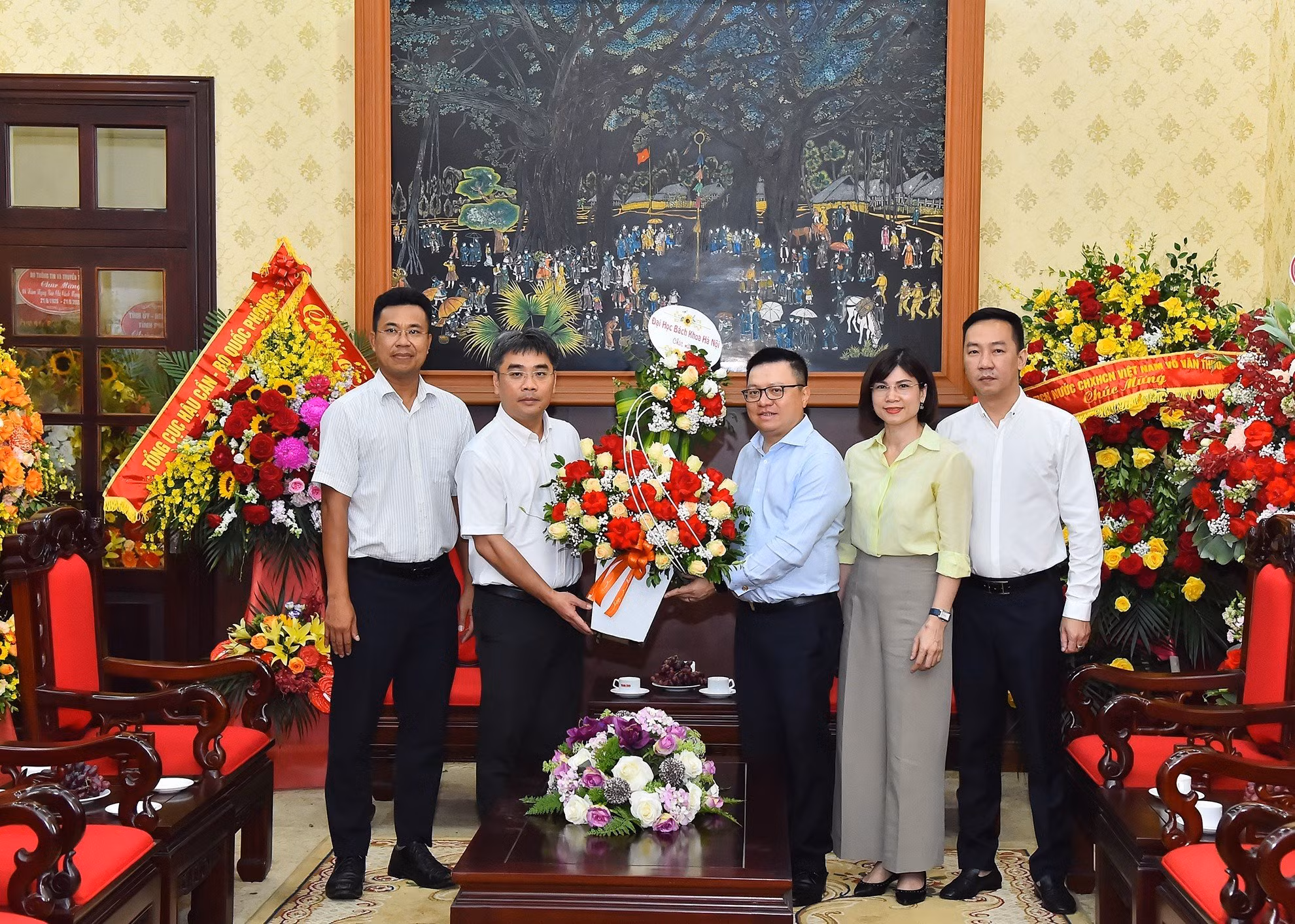 Phó Giáo sư Huỳnh Đăng Chính, Phó Giám đốc Đại học Bách khoa Hà Nội tặng hoa, chúc mừng Báo Nhân Dân.