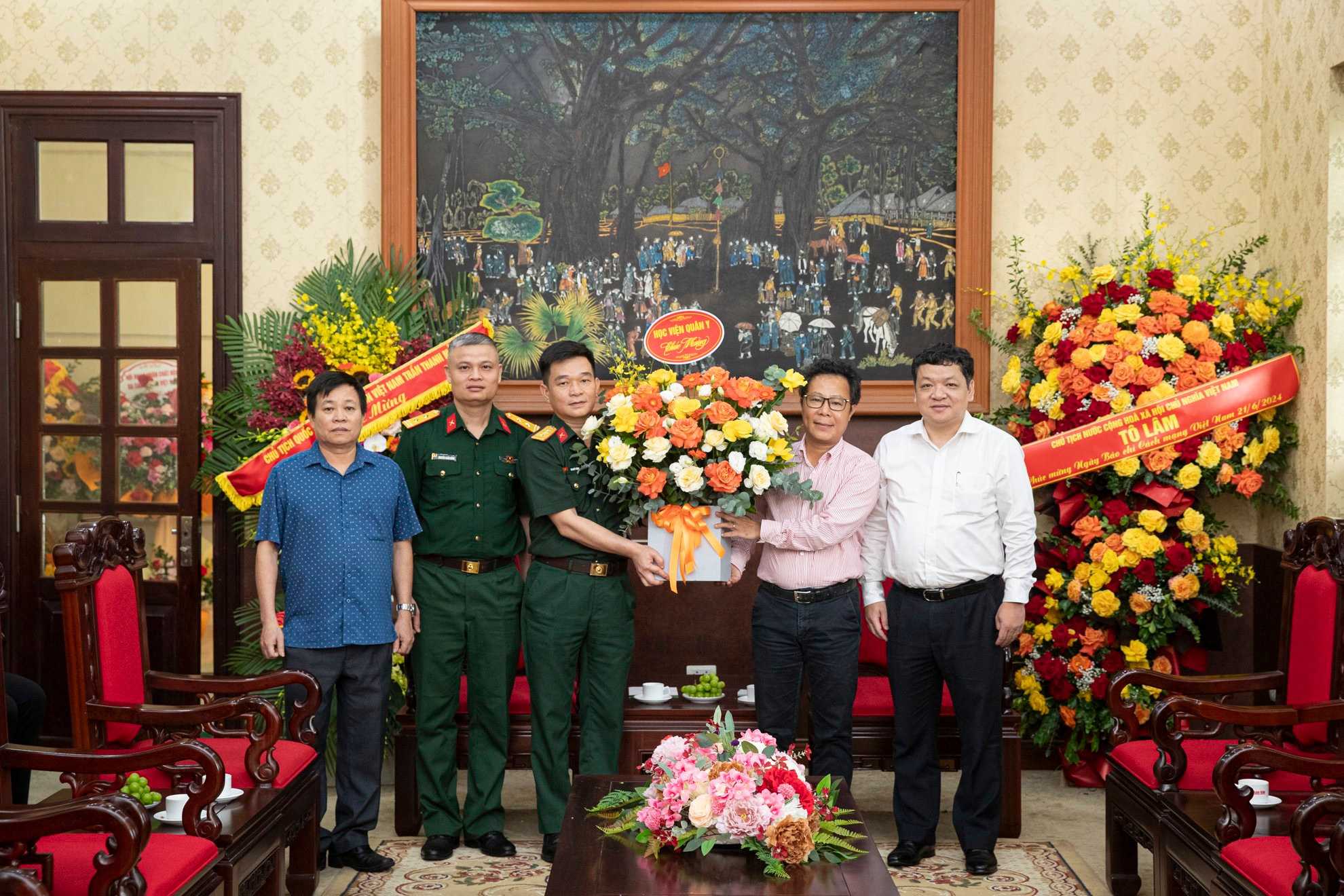 Đại diện những người làm Báo Nhân Dân nhận lẵng hoa tươi thắm của Học viện Quân y.