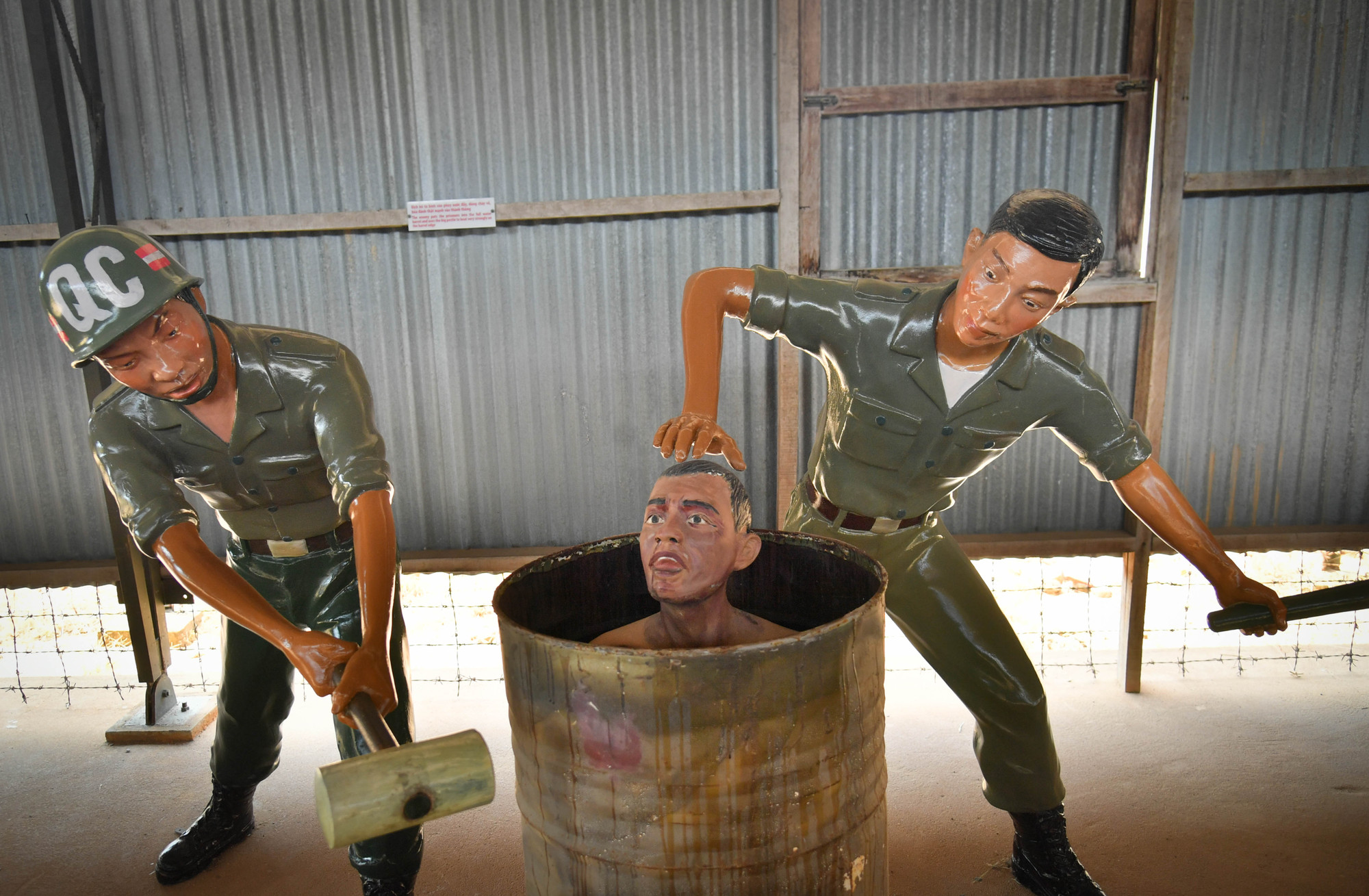 Đáng sợ hơn, chúng tống tù nhân vào thùng đầy nước, một tên ấn đầu xuống, một tên dùng vồ đập mạnh khiến các chiến sĩ bị sặc nước và vỡ tai đau đớn.