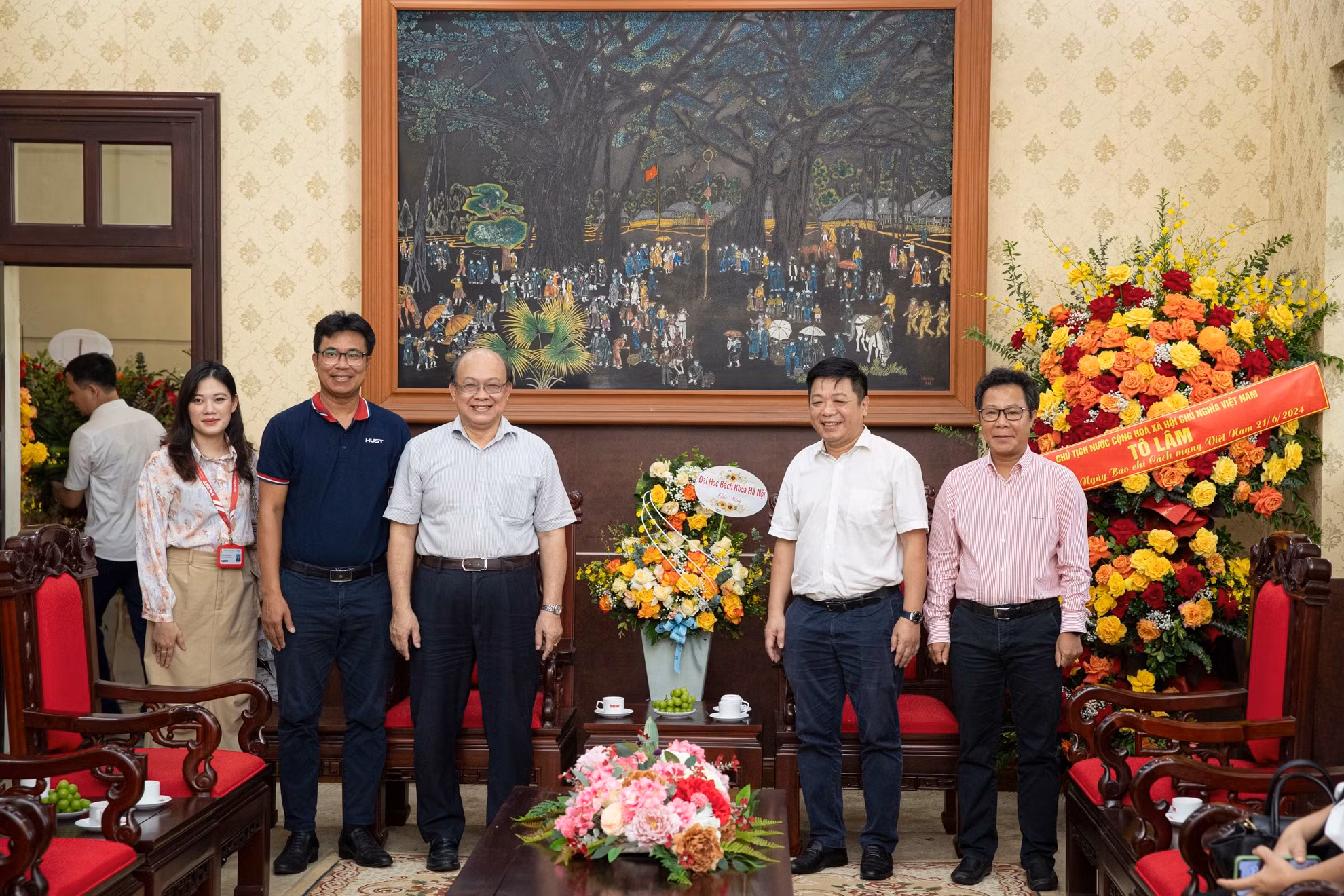 PGS, TS Huỳnh Quyết Thắng, Giám đốc Đại học Bách Khoa Hà Nội tặng lẵng hoa tươi thắm và chụp ảnh lưu niệm cùng Phó Tổng Biên tập Báo Nhân Dân Quế Đình Nguyên.