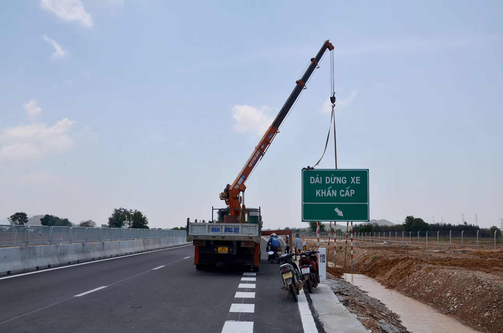 Trưa ngày 18/5, đơn vị thi công thuộc gói thầu XL-04 cao tốc Vĩnh Hảo-Phan Thiết vẫn đang tiến hành lắp đặt biển chỉ dẫn vị trí dừng xe khẩn cấp đi qua địa bàn xã Hồng Sơn, huyện Hàm Thuận Bắc.