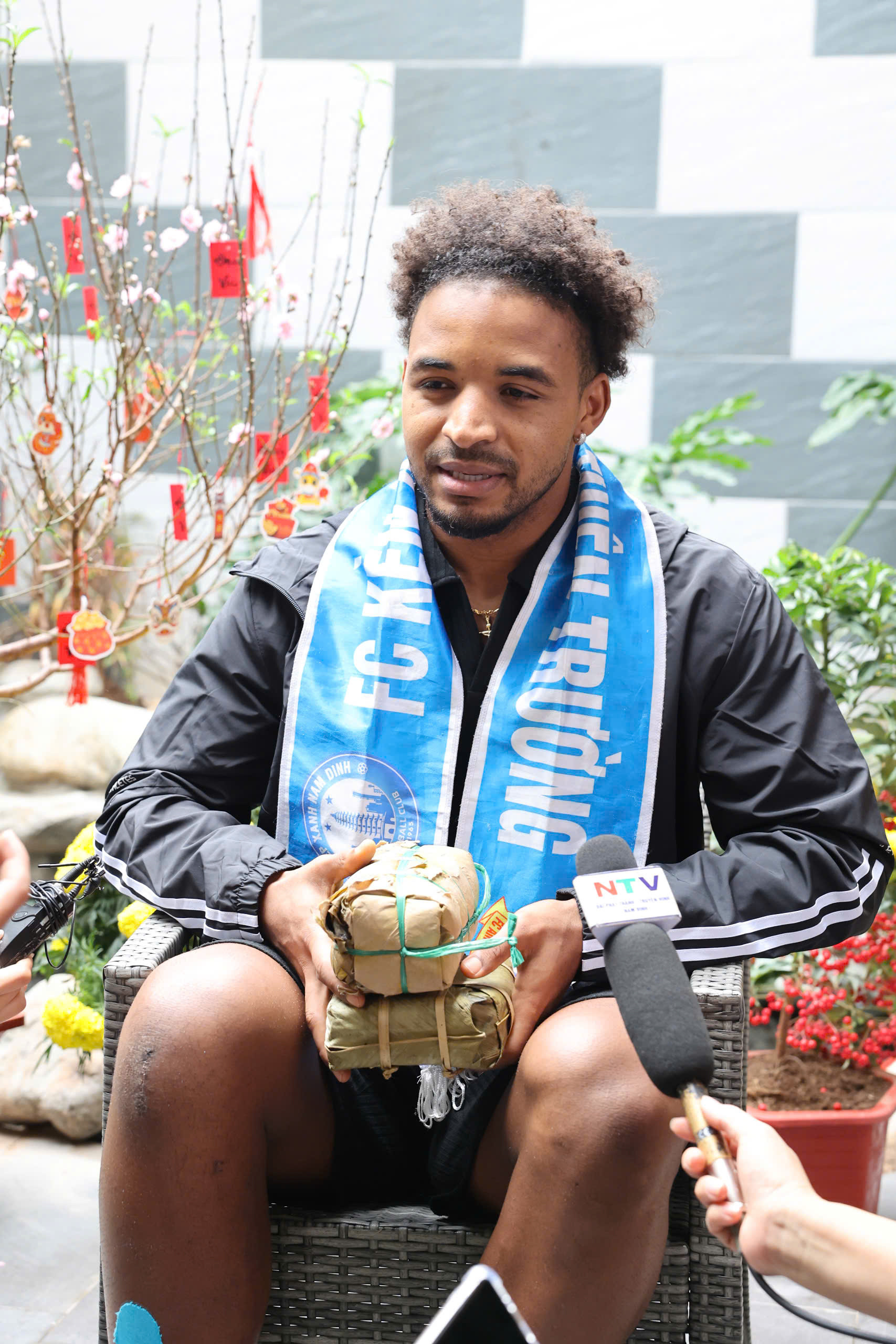 Trên tay cầu thủ mang áo số 12 của Đội tuyển Việt Nam là bánh chưng và giò do một số cổ động viên dành tặng. Với anh, đây có lẽ sẽ là cái Tết đoàn viên đặc biệt nhất.