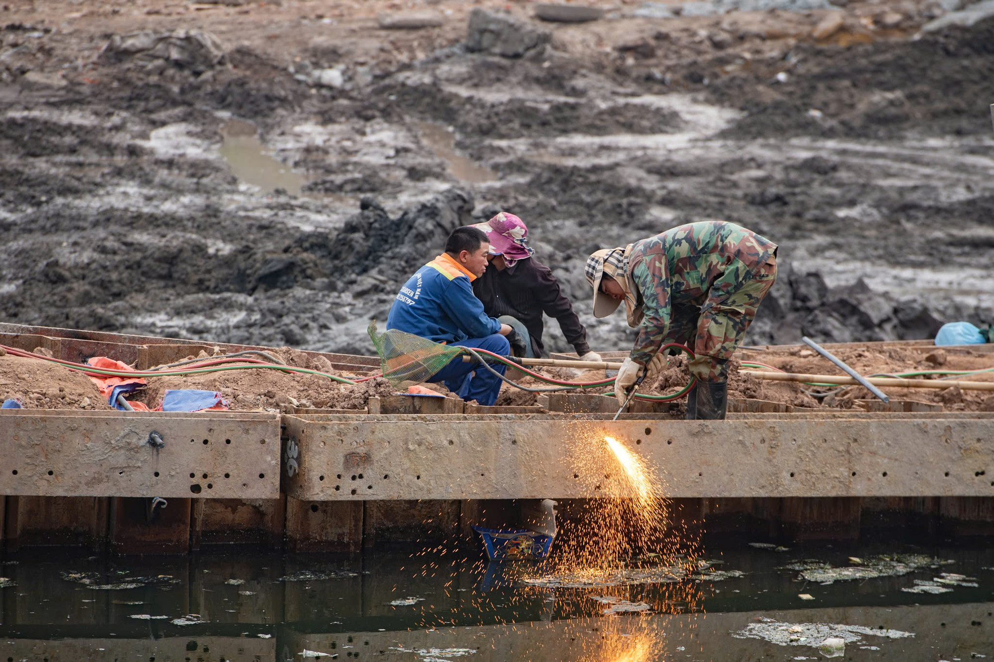 Các công nhân làm việc trên công trình xây đập dâng giữ nước đầu tiên trên sông Tô Lịch.