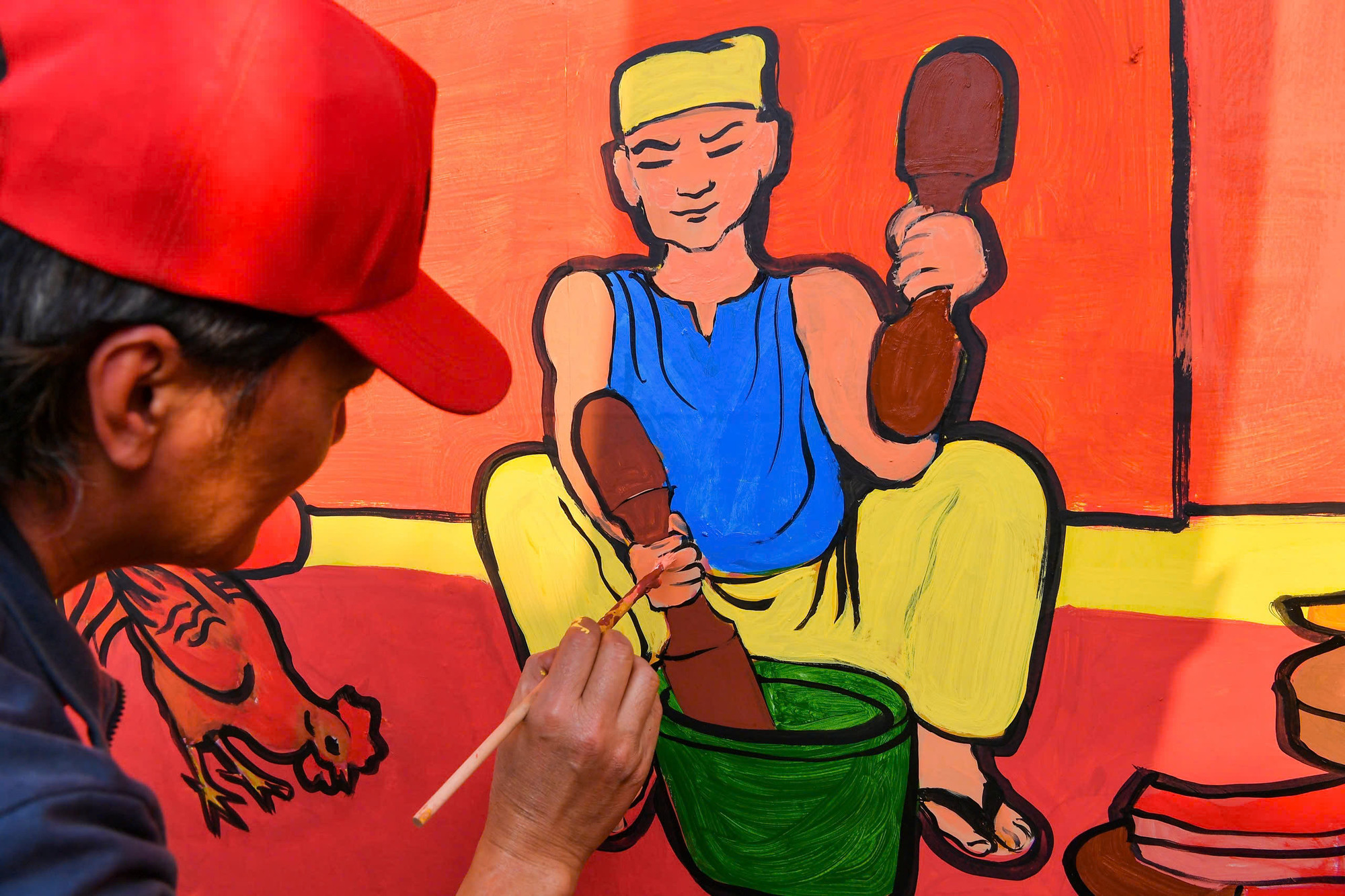 Họa sĩ chỉnh lại những nét nhấn cuối cùng của bức tranh đại cảnh trên thân toa tàu ngày Tết.