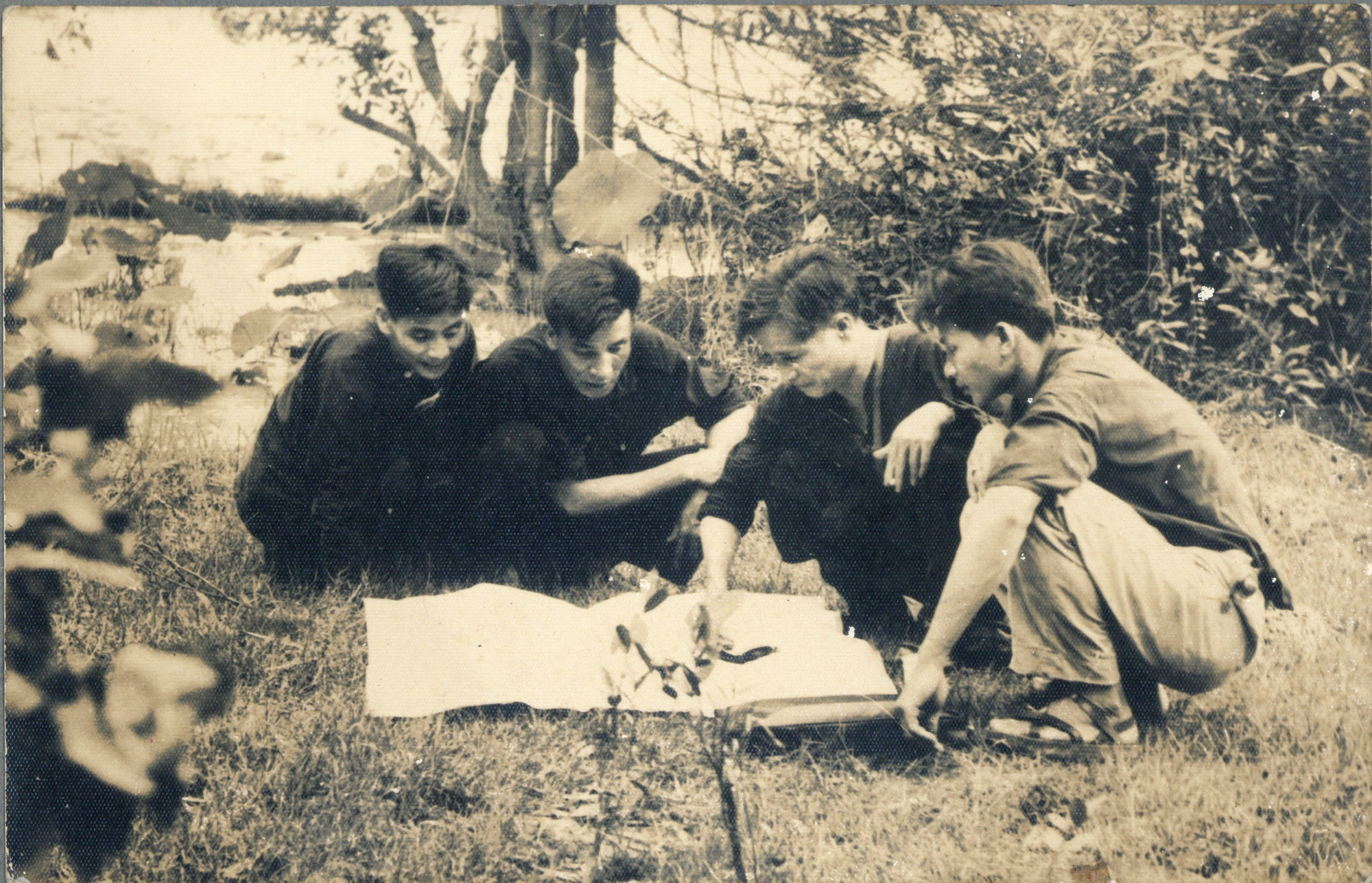 Đại tướng Nguyễn Chí Thanh cùng các cán bộ xem xét bản đồ tác chiến tại Trảng Lớn, khu vực Kà Tum, cuối năm 1964. Từ trái qua: đồng chí Tùng - Giao liên Trung ương Cục; đồng chí Tám Trần - Thư ký Đại tướng Nguyễn Chí Thanh; đồng chí Chiến - Bảo vệ.