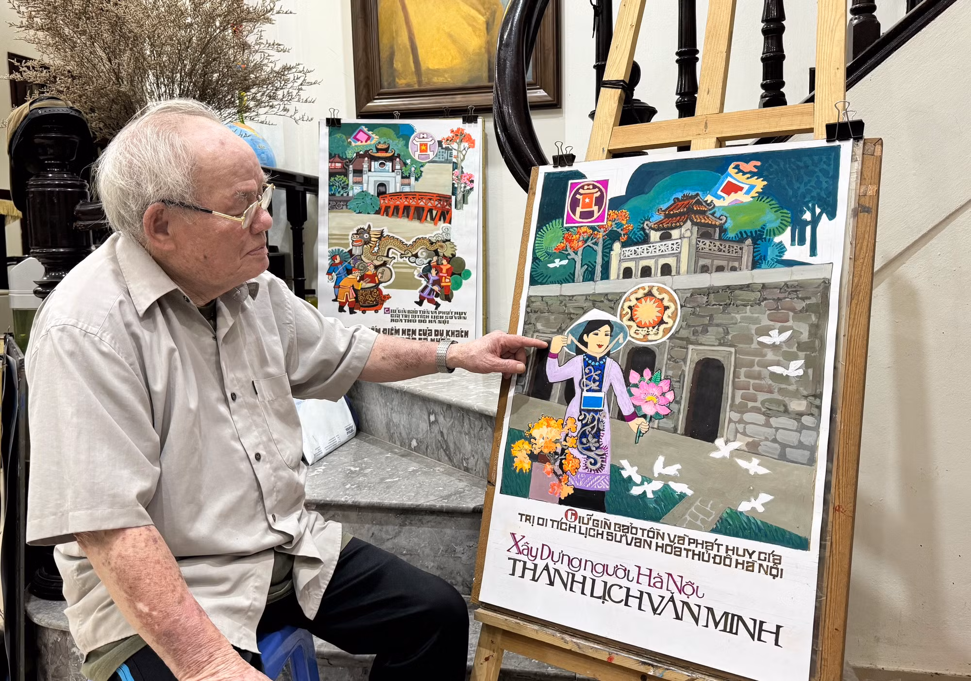 Họa sĩ Trần Duy Trúc bên các tác phẩm của mình.