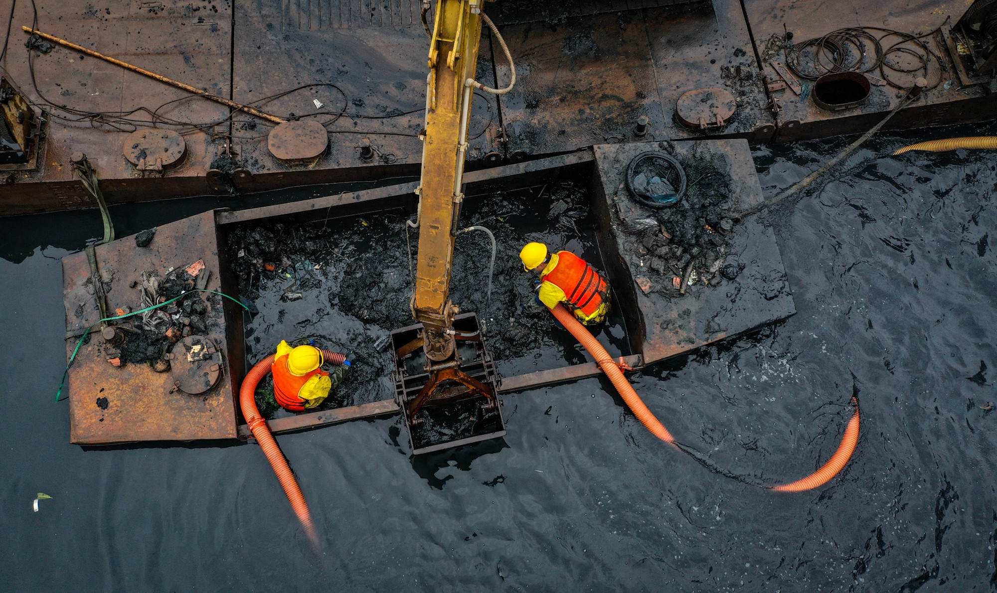 Mặc dù trời mưa rét, nhưng từ sáng sớm, các công nhân thuộc Xí nghiệp Thi công cơ giới - xây lắp, Công ty TNHH MTV Thoát nước Hà Nội đã bắt đầu... vào ca. Địa điểm làm việc là khúc sông thượng nguồn nằm gần ngã tư Hoàng Quốc Việt - Bưởi.