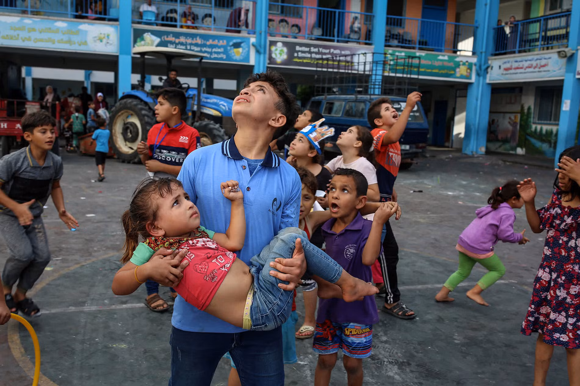 Những đứa trẻ Palestine nhìn lên bầu trời khi nghe thấy âm thanh của vụ không kích tại một trường học do Liên hợp quốc điều hành ở Gaza. Ảnh: Samar Abu Elouf/The New York Times/Redux