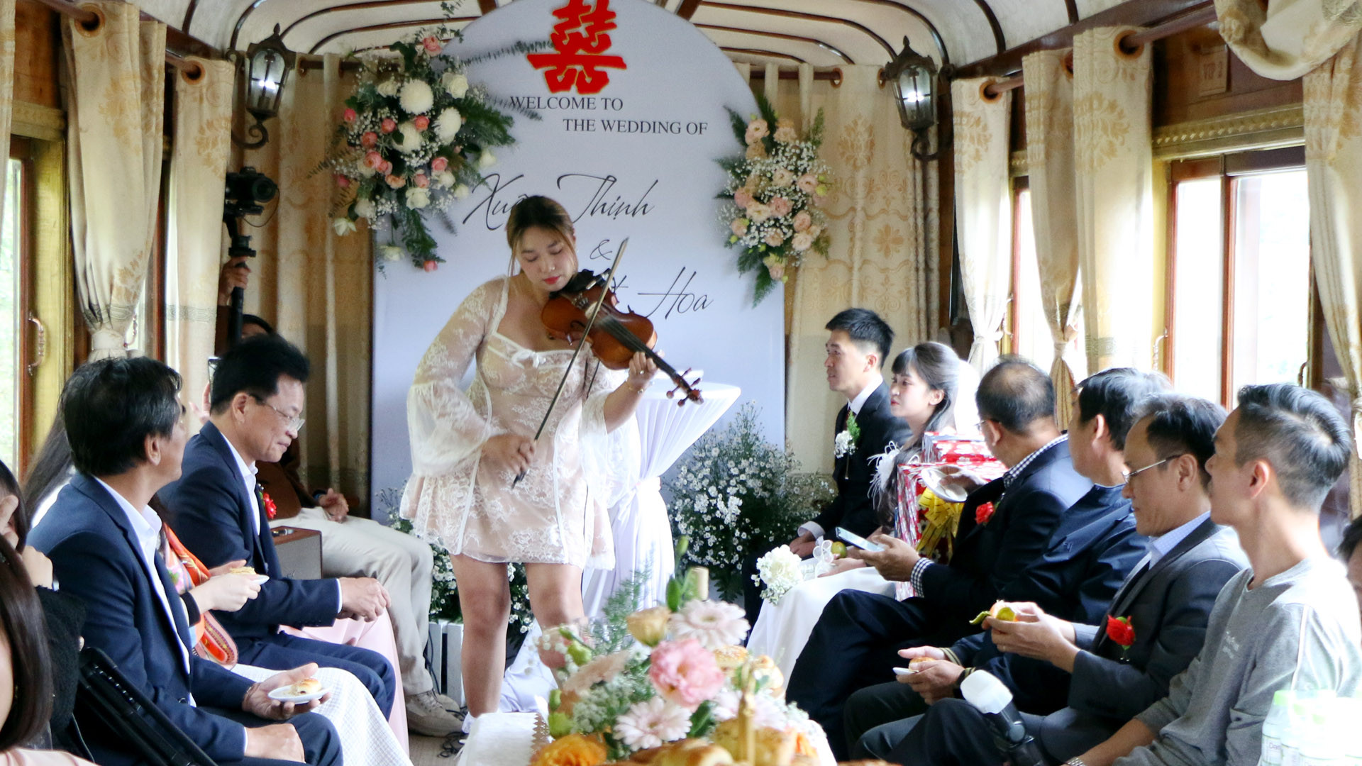 Đoàn tàu xình xịch ngang qua những cánh rừng, những vườn rau xanh mát, những vườn hoa khoe sắc ven đô, mang theo những lời chúc mừng trên nền nhạc violon lãng mạn của nghệ sĩ.