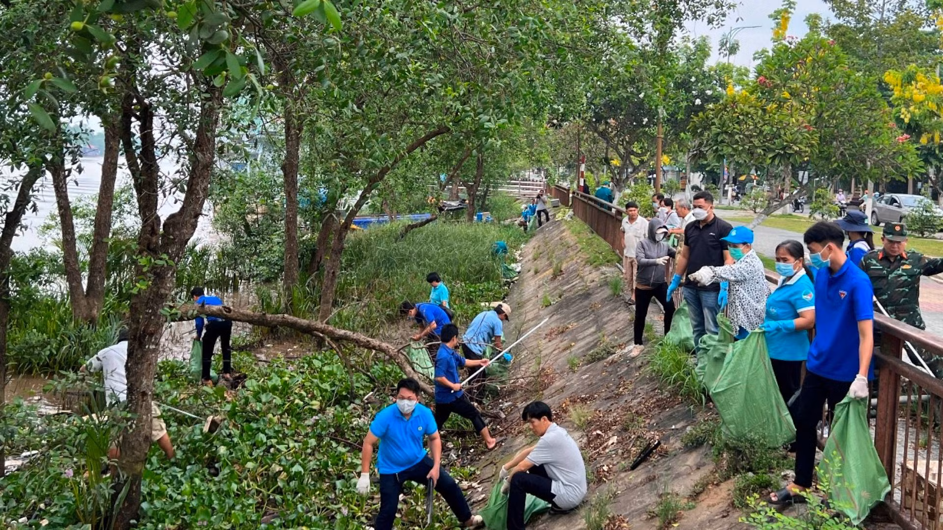 Lực lượng đoàn viên, thanh niên cùng người dân địa phương tham gia vớt rác, dọn vệ sinh cặp bờ sông Bến Tre. (Ảnh: HOÀNG TRUNG)