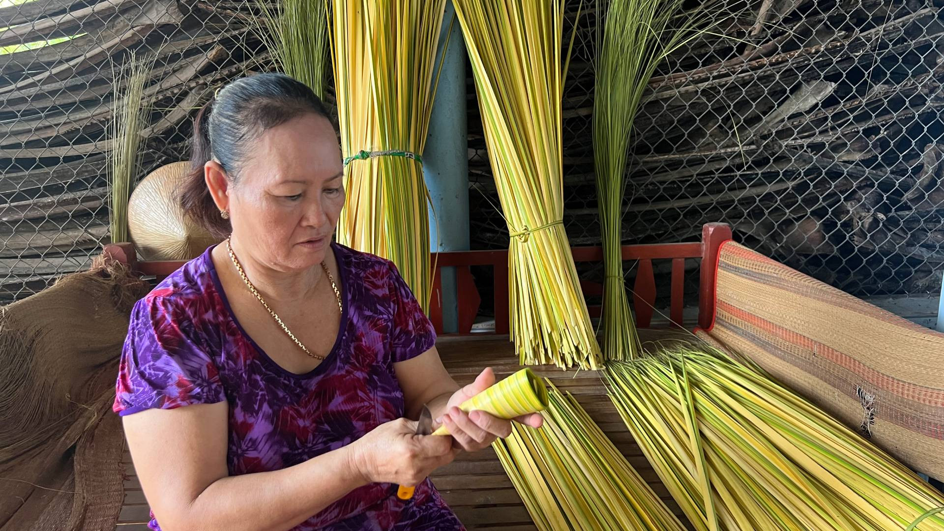 Bà Đoàn Thị Bé tạo khung từ lá dừa nước non để gói bánh