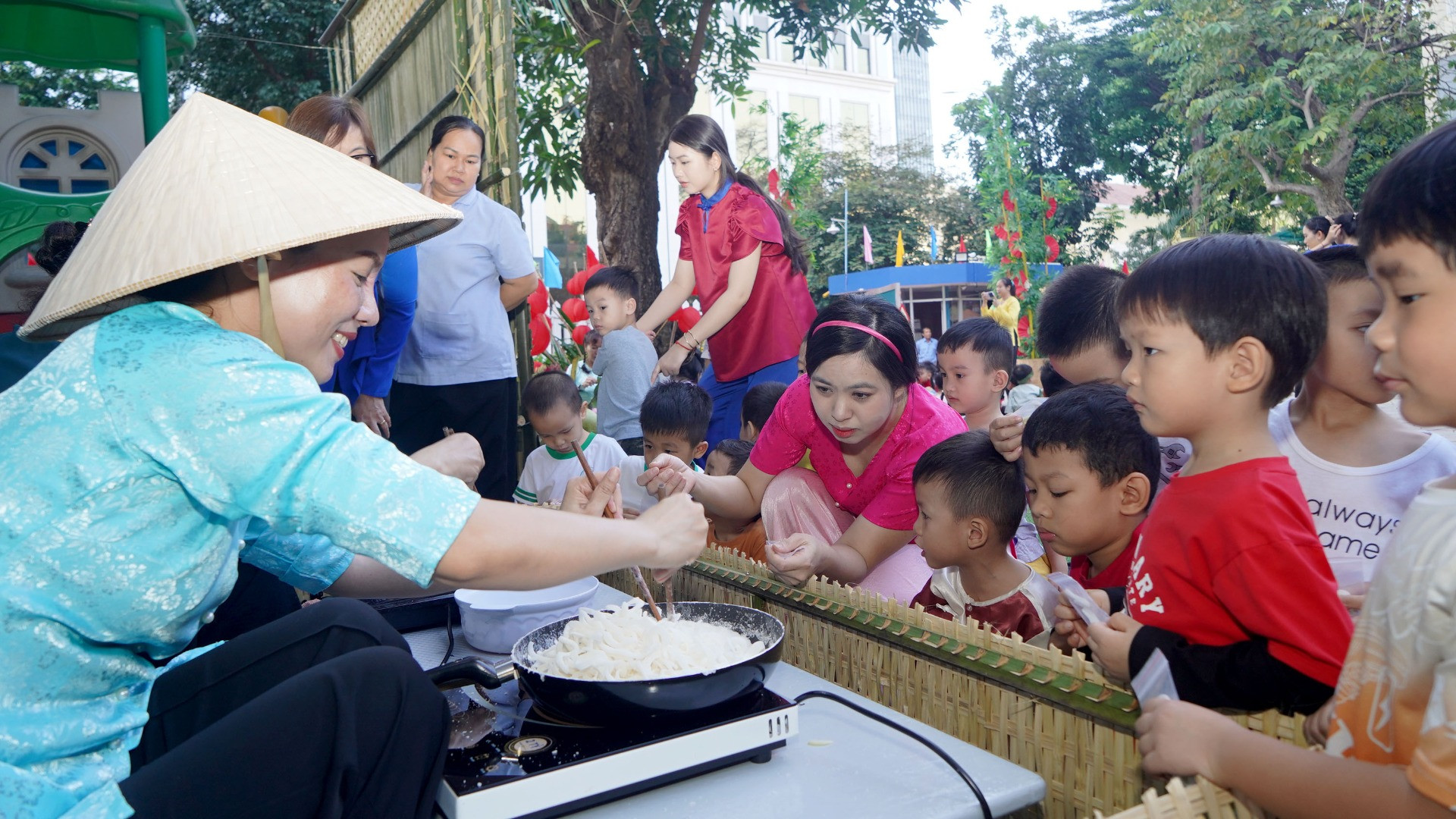 Các em nhỏ háo hức xem các cô giáo hướng dẫn làm mứt dừa.