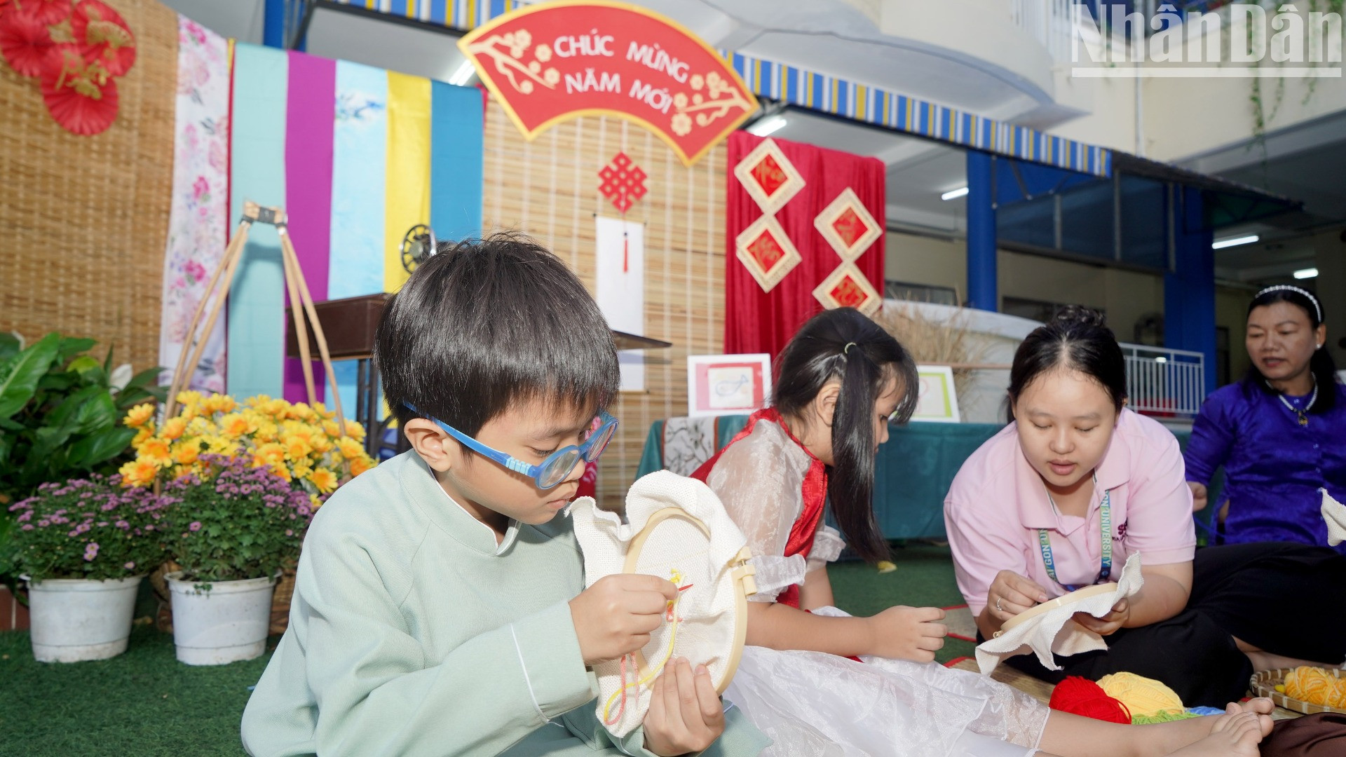 Các bé tham gia trải nghiệm cách thêu hình trên vải.