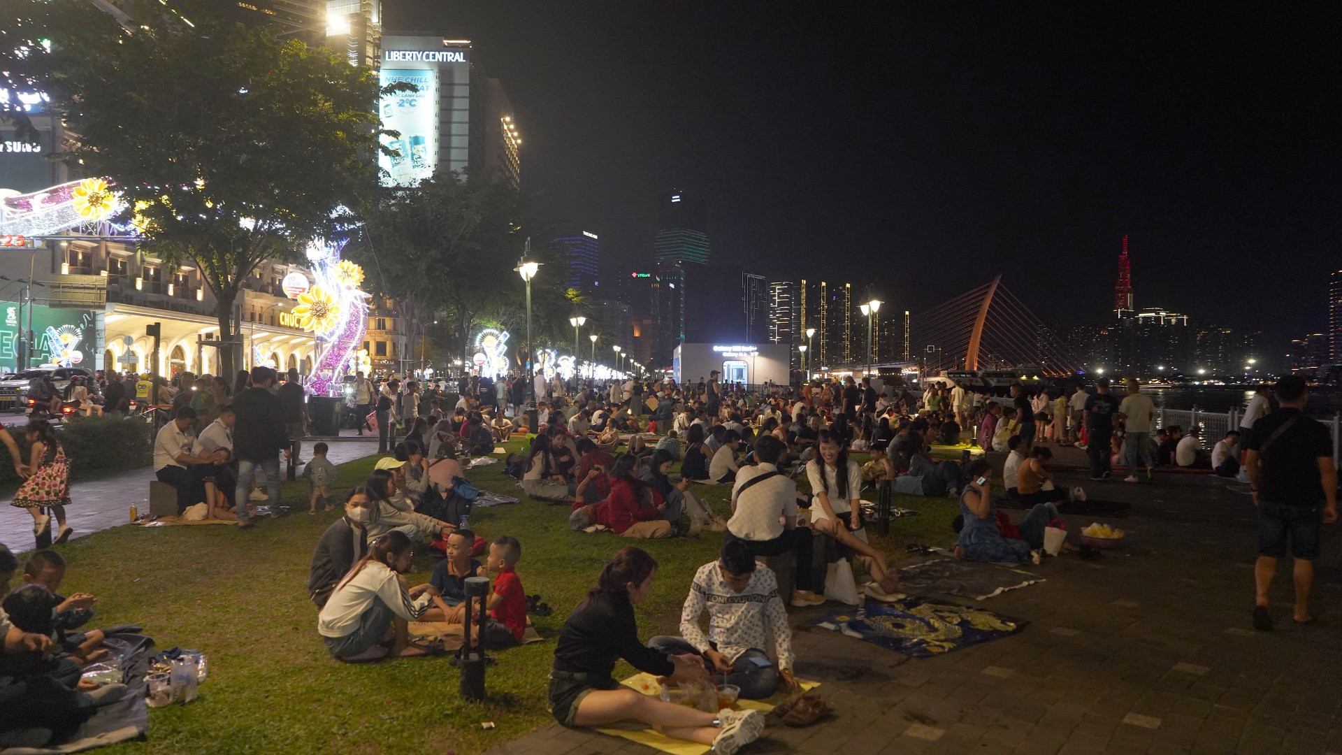 Đông đảo người dân đã có mặt từ rất sớm tại công viên bến Bạch Đằng để chờ đợi màn trình diễn pháo hoa nghệ thuật đầu đường hầm sông Sài Gòn.