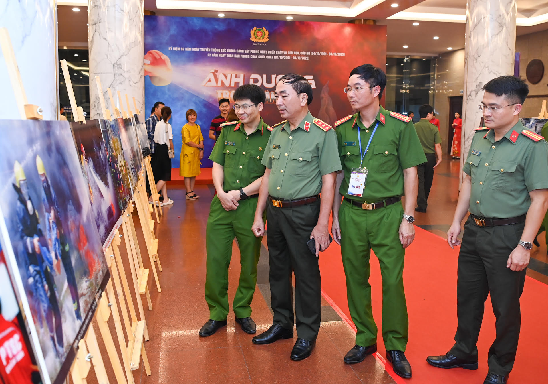 Các đại biểu tham quan trưng bày ảnh về công tác phòng cháy, chữa cháy và cứu nạn, cứu hộ tại buổi lễ.