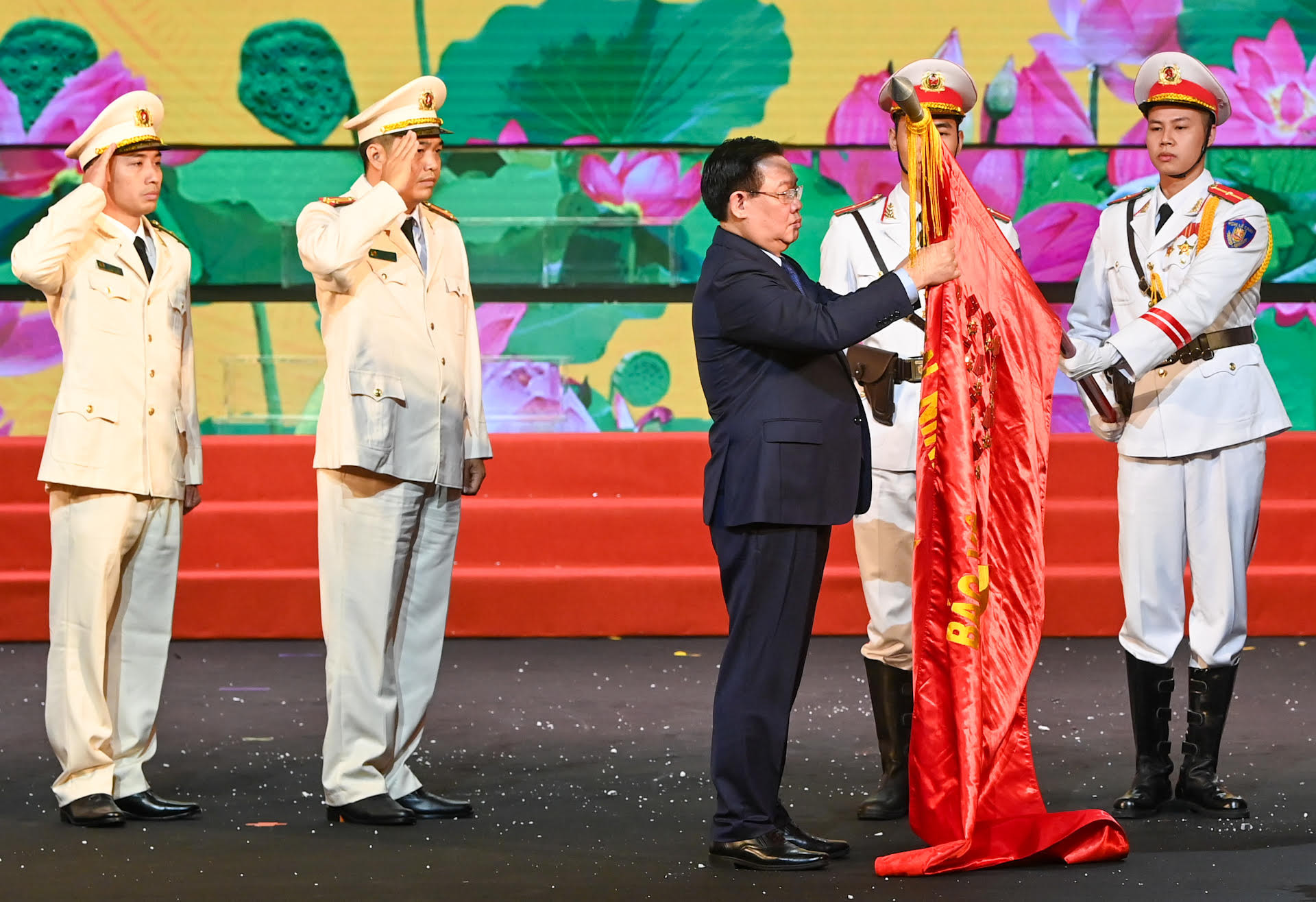 Chủ tịch Quốc hội Vương Đình Huệ gắn Huân chương lên lá cờ truyền thống của lực lượng Cảnh sát phòng cháy, chữa cháy và cứu nạn, cứu hộ.