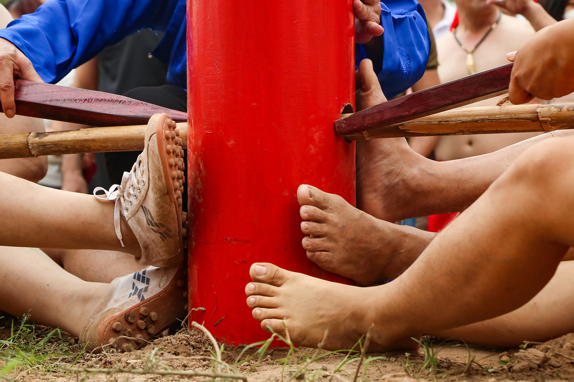 Những người ở hàng đầu dùng chân đạp vào cột lim để cố định vị trí, giúp việc kéo dây song dễ dàng hơn.