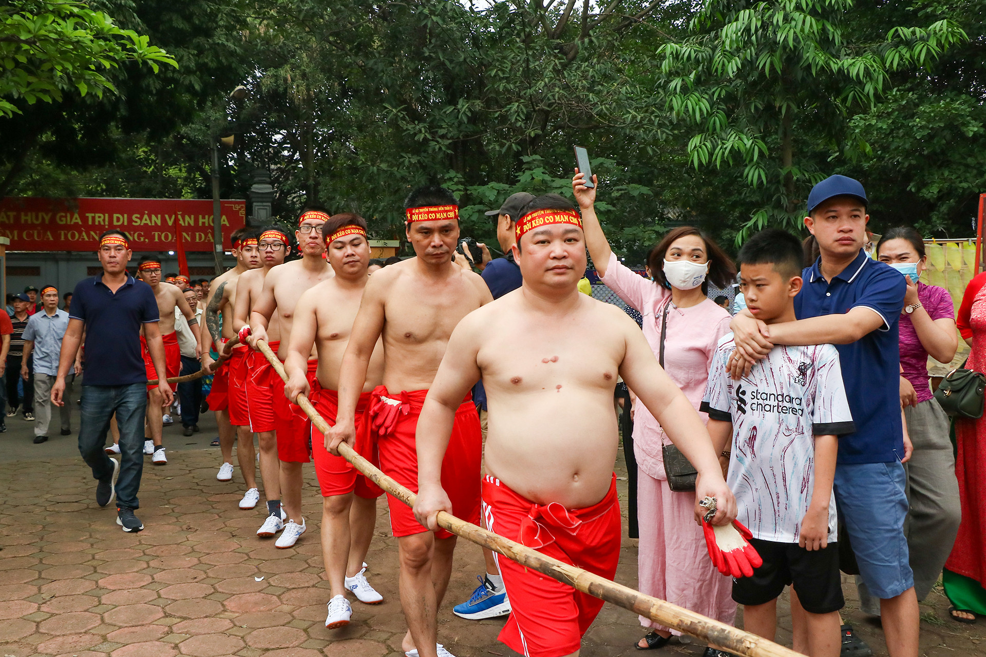 Các đội truyền tay nhau cây song mang đến khu vực sới kéo, cây song có chiều dài lên đến 50m, đường kính 5cm. Năm nay mỗi đội có 19 người tham gia, 1 tổng cờ và 3 ông tổ trưởng hoặc tổ phó tổ dân phố điều khiển chốt nêm và rút nêm và hiệu lệnh trọng tài (bằng còi, trống khẩu và loa).