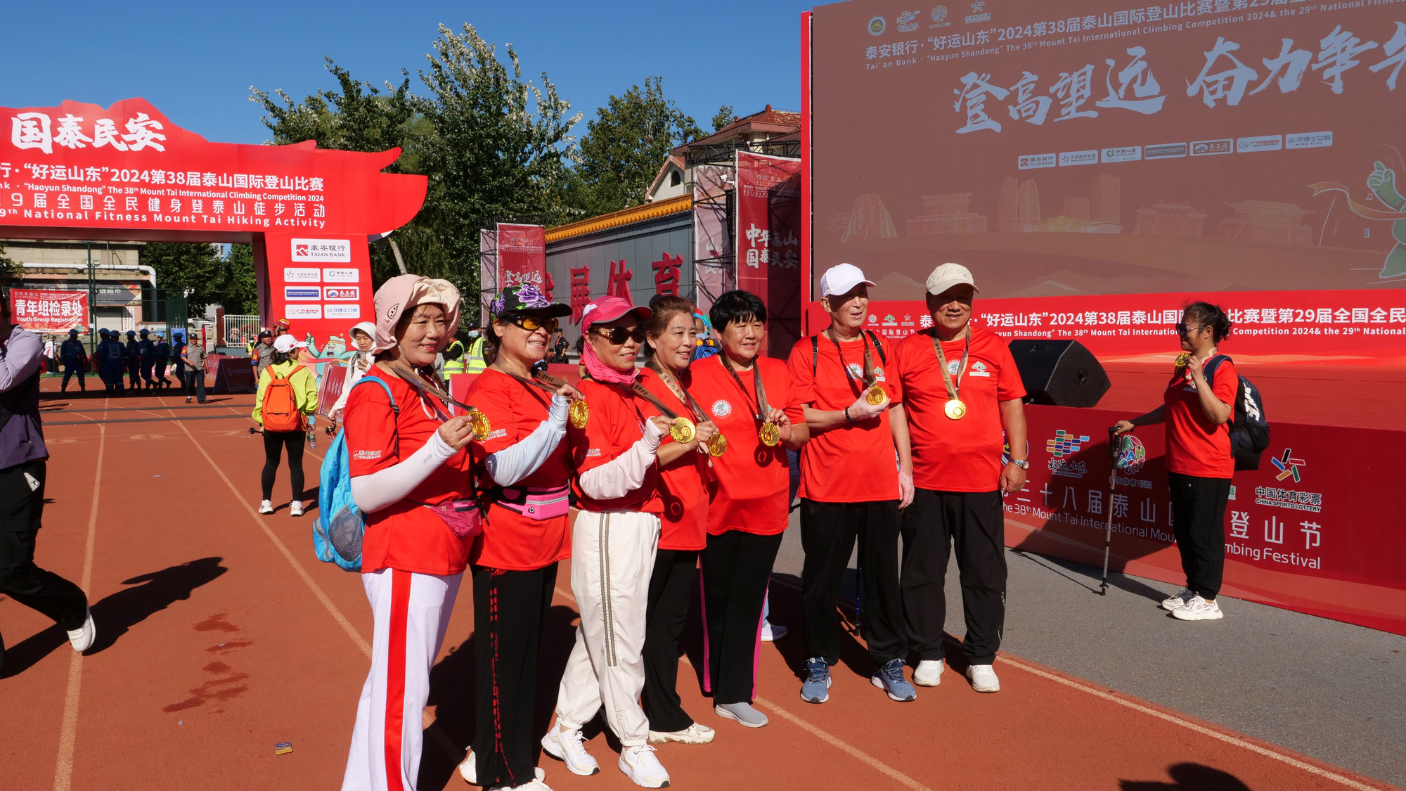 Vận động viên người cao tuổi chụp ảnh lưu niệm với huy chương vàng.