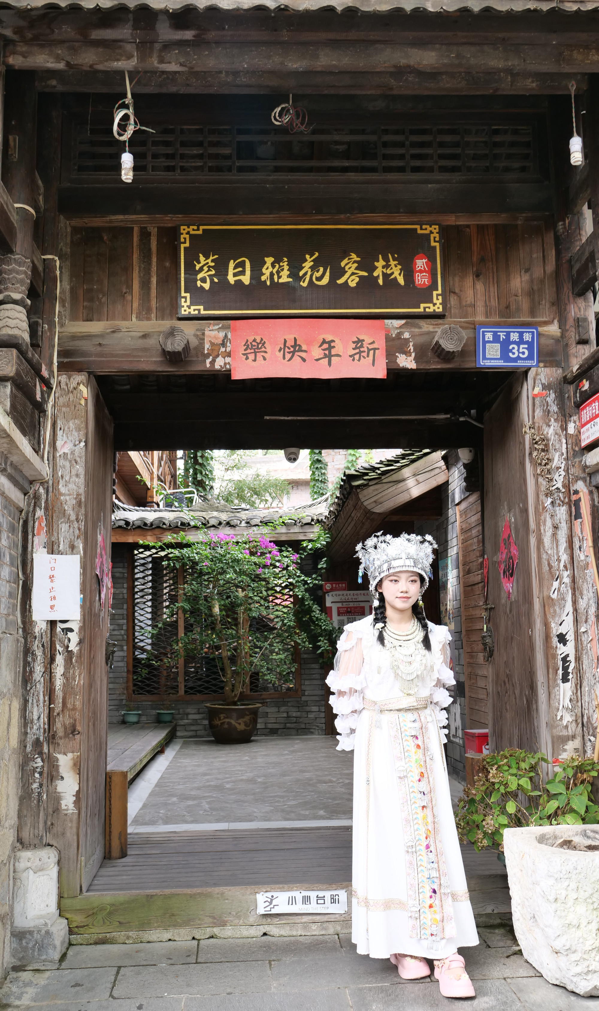 Thiếu nữ chụp ảnh trước cổng một ngôi nhà cổ.